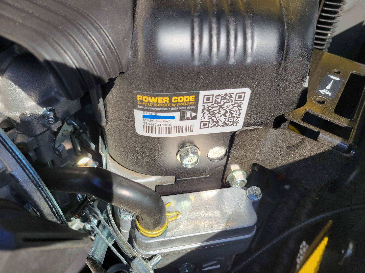 Mini skid steer 23 HP tracked loader engine close up detail showing power code label in Canada