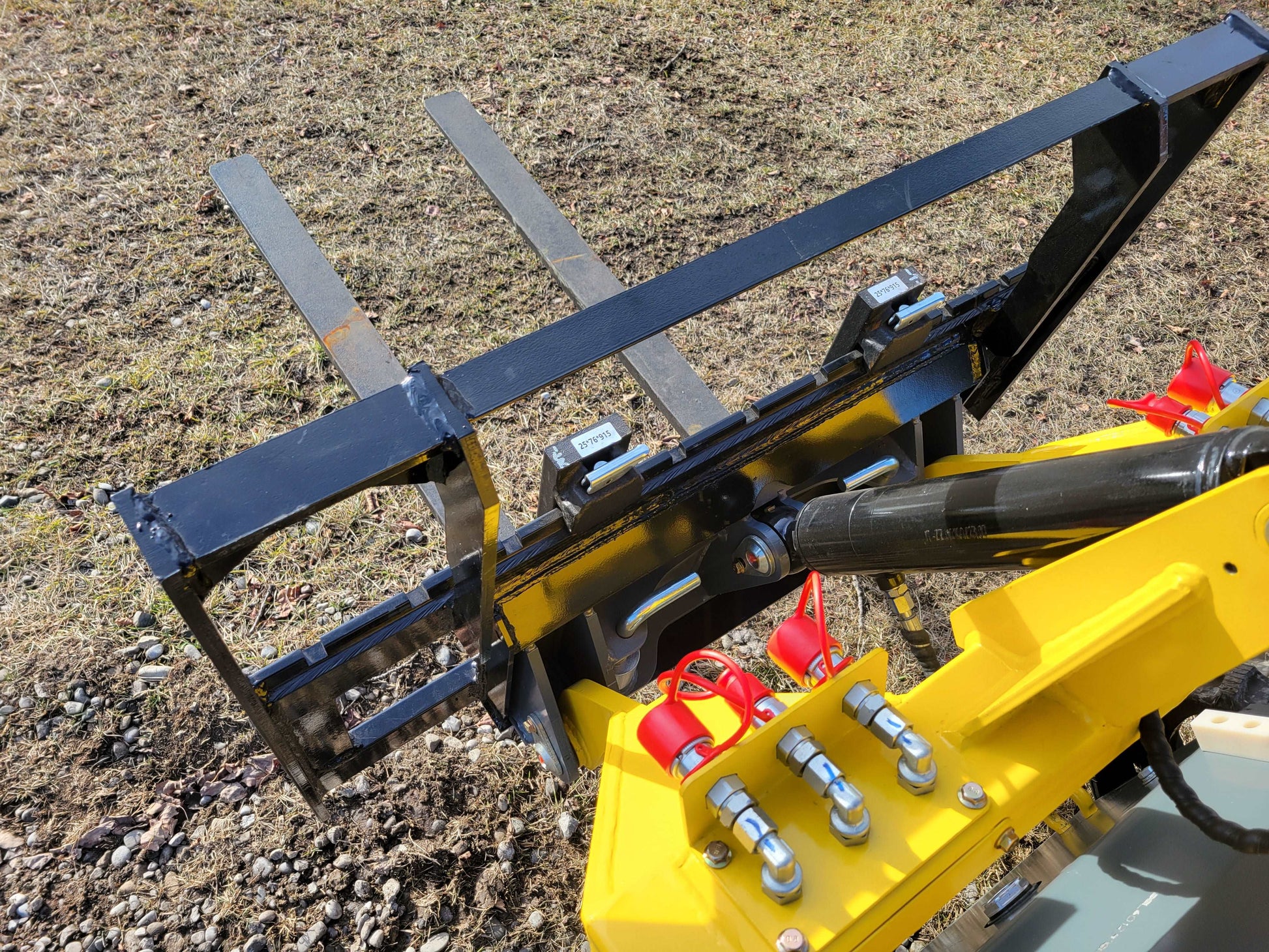 Mini tracked skid steer 23 HP loader fork attachment close up showing hydraulic connection detail in Canada

