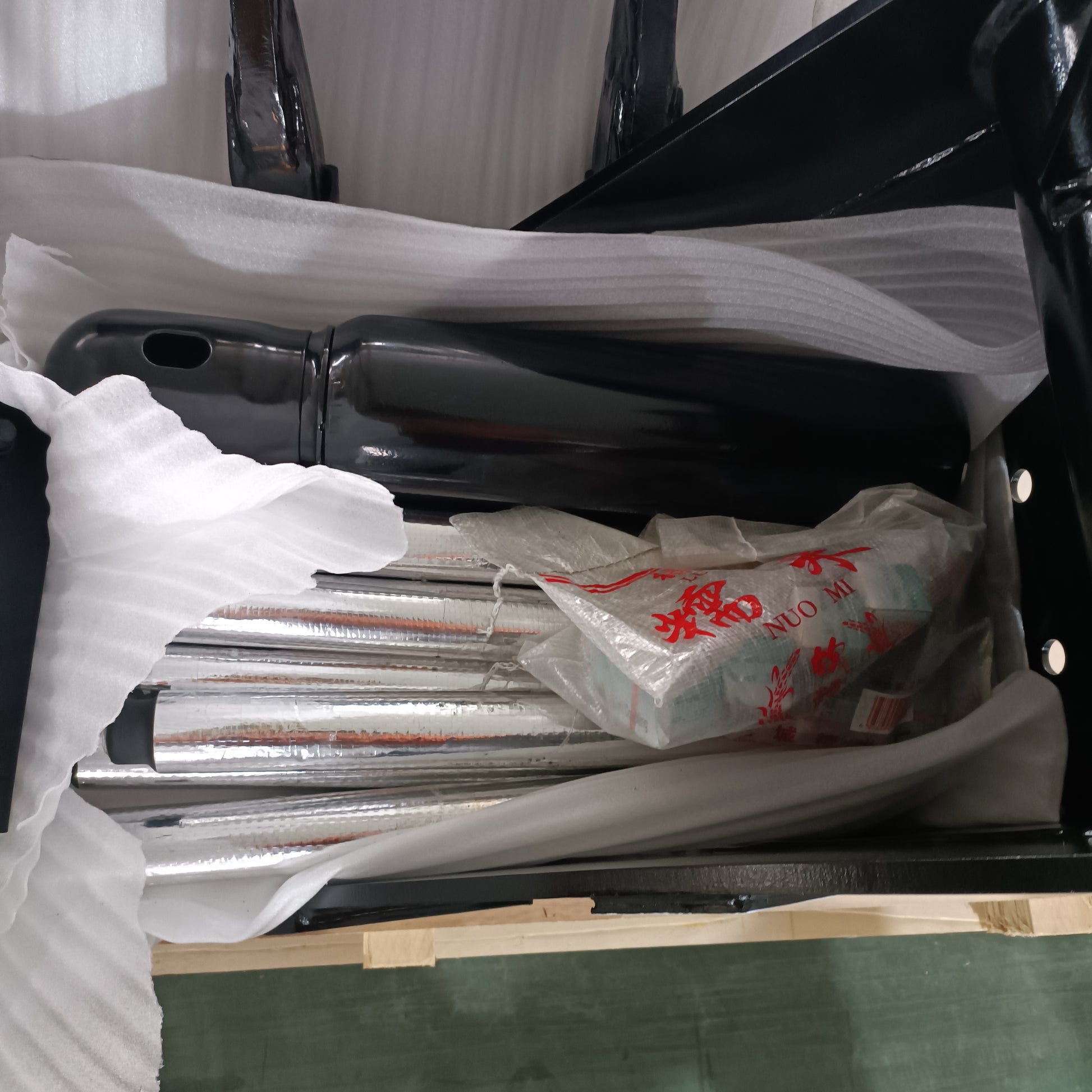 Packaged custom excavator attachments made in Canada prepared for safe shipping including hydraulic and metal parts for construction equipment