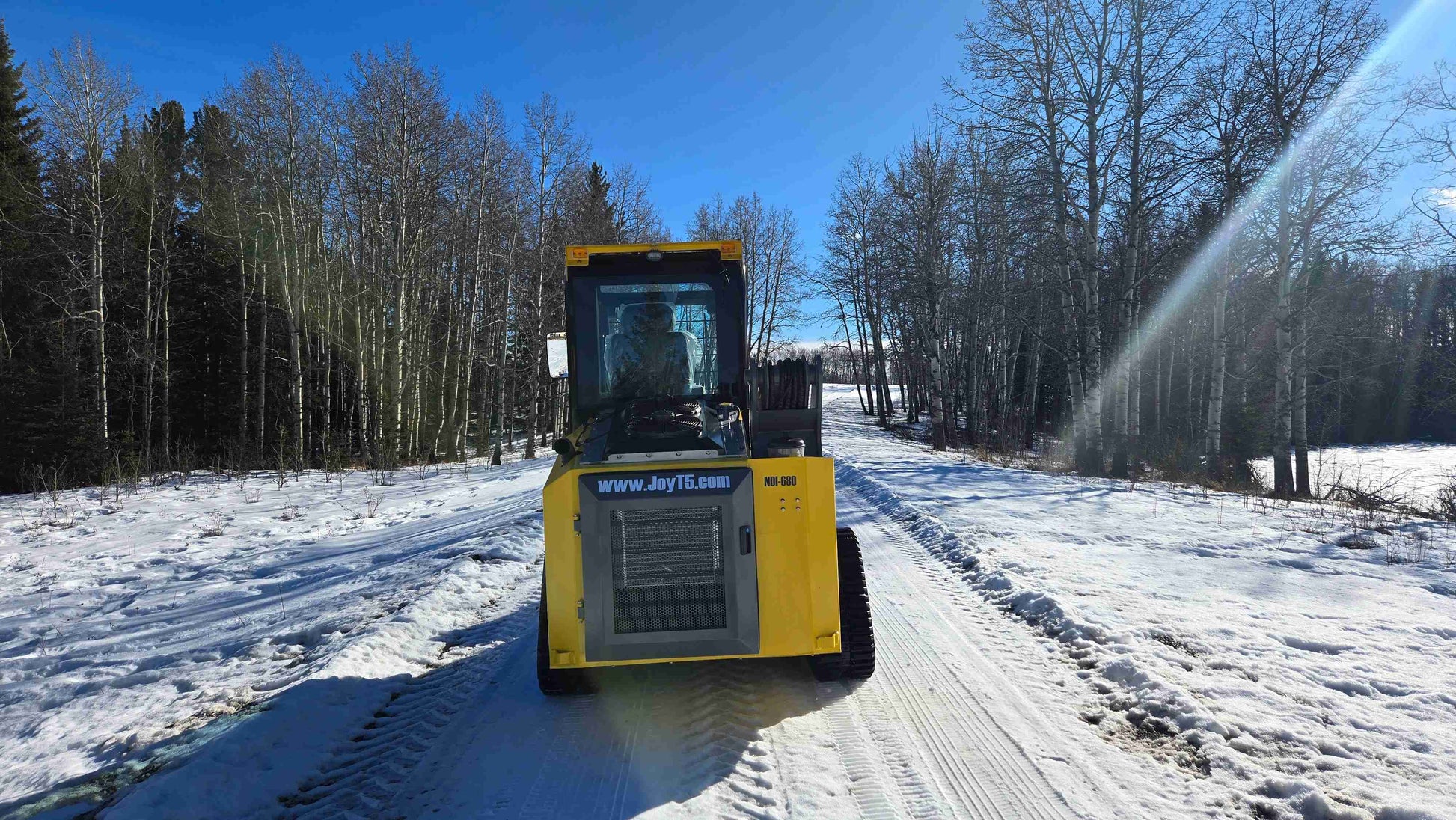 Front view of Rippa NDI680 skid steer loader 74 HP compact machine on snowy path in Canada – best heavy duty skid steer for construction | JoyT5