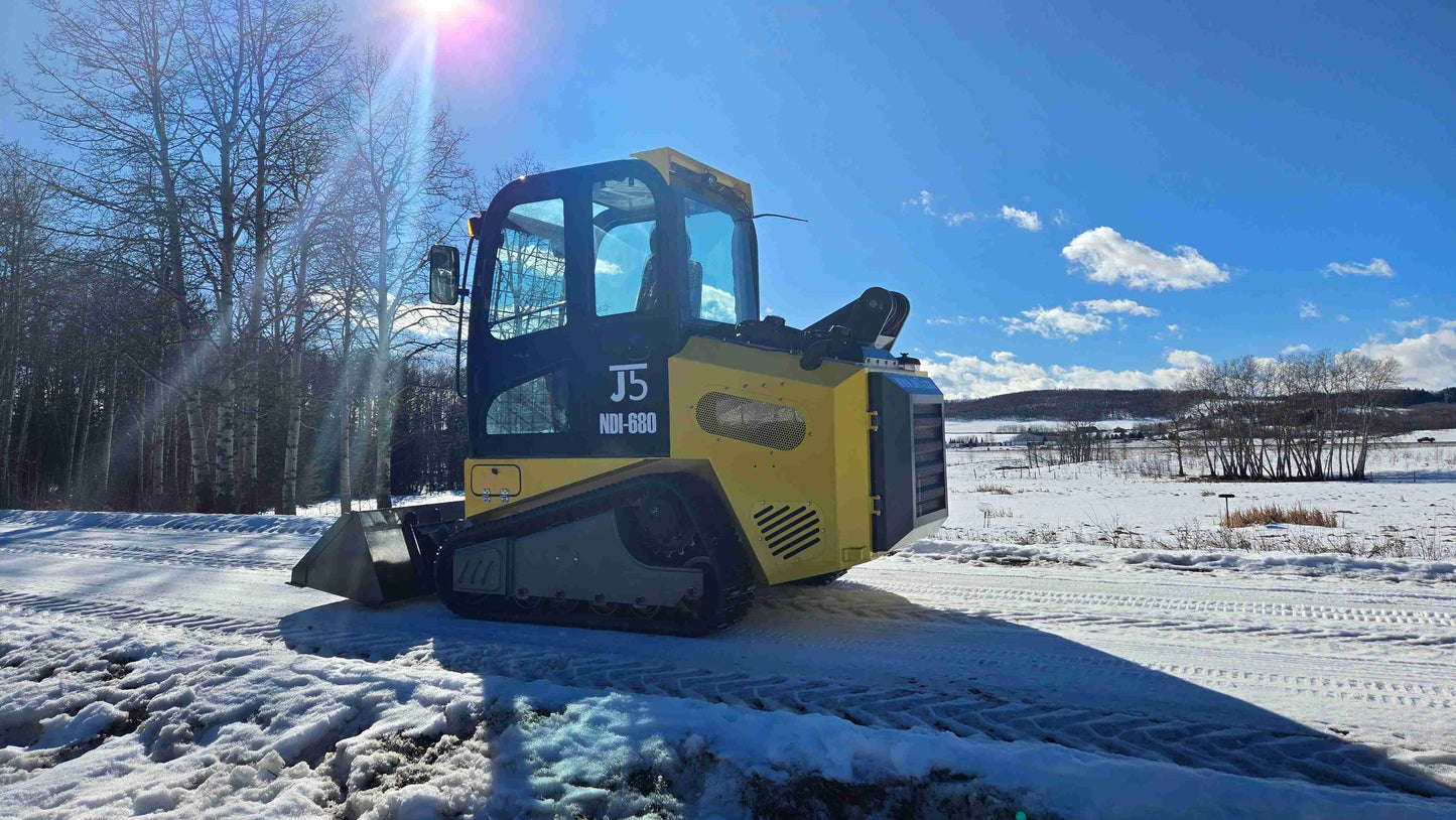 Rippa NDI680 skid steer 74 HP diesel machine showing winter performance on snow with enclosed cabin and bucket for farming and construction use in Canada by JoyT5