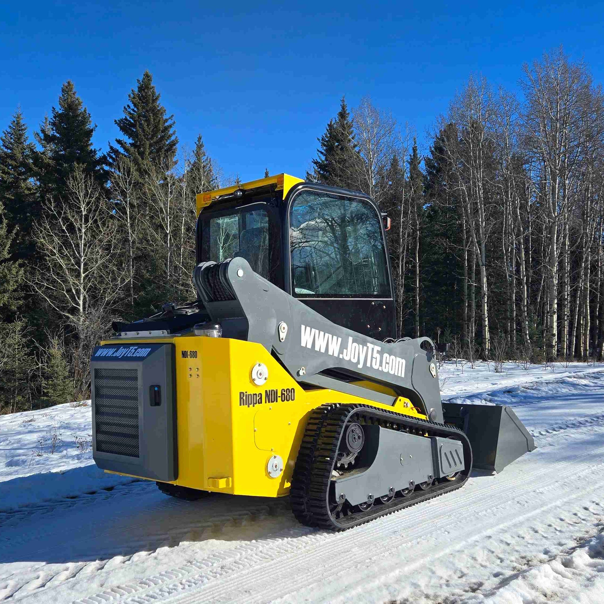 Rippa NDI680 skid steer 74 HP shown from rear angle driving on snowy rural road demonstrating winter traction and stability in Canada by JoyT5