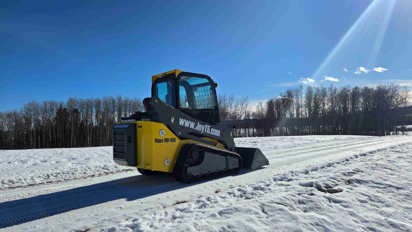 Rippa NDI680 skid steer 74 HP rear side view operating on snow road showing compact tracked loader for construction landscaping and farming work in Canada by JoyT5