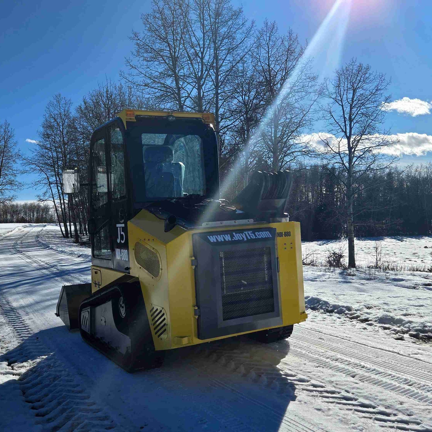 Rippa NDI680 skid steer 74 HP diesel loader shown from rear driving on snowy road demonstrating winter reliability in Canada by JoyT5