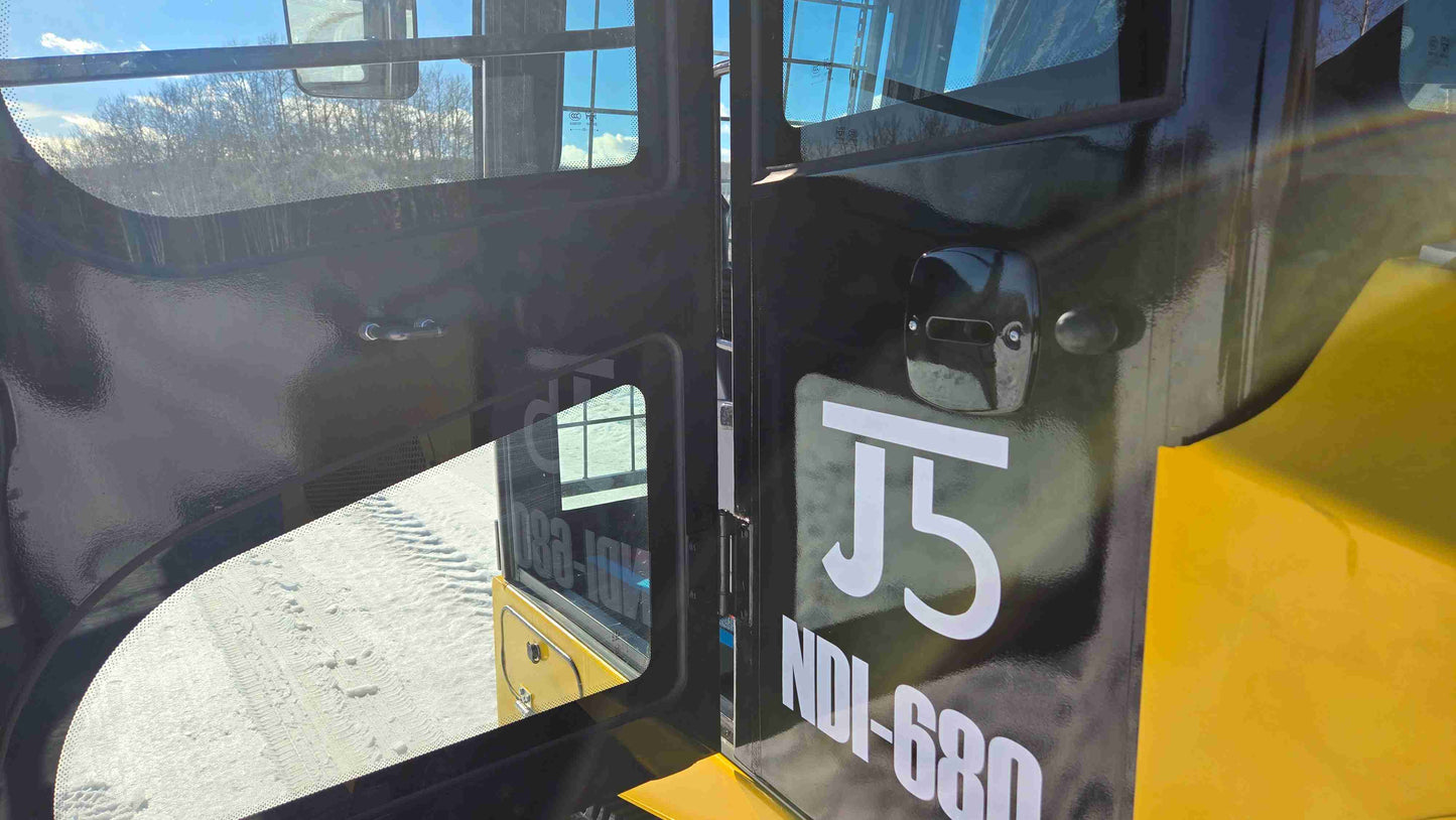 Open cabin door view of Rippa NDI680 skid steer showing reinforced safety glass and enclosed operator cab designed for construction landscaping and farming work across Canada by JoyT5
