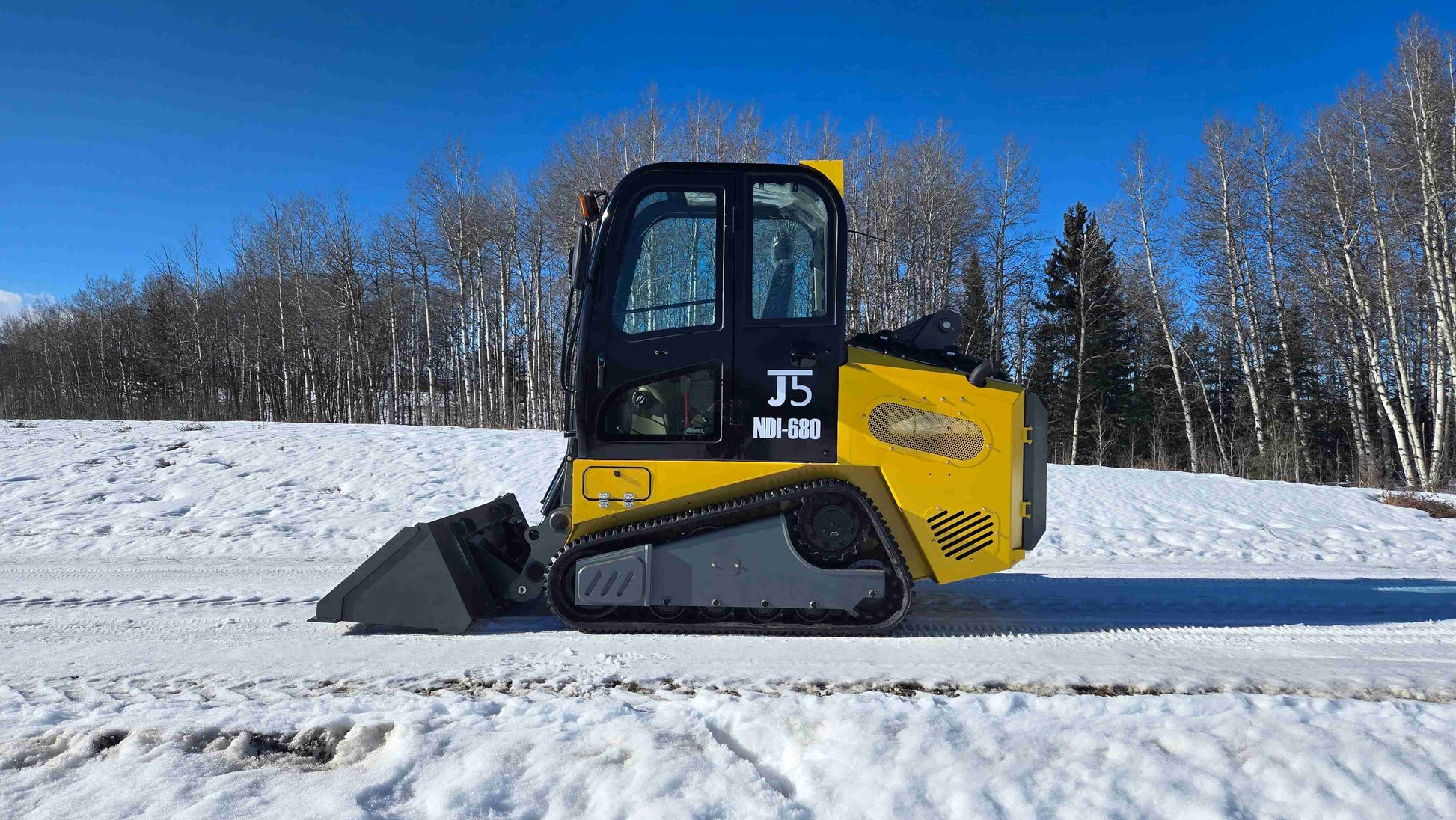 rippa NDI680 skid steer 74 HP compact tracked loader on snowy field for construction landscaping and snow clearing in Canada

