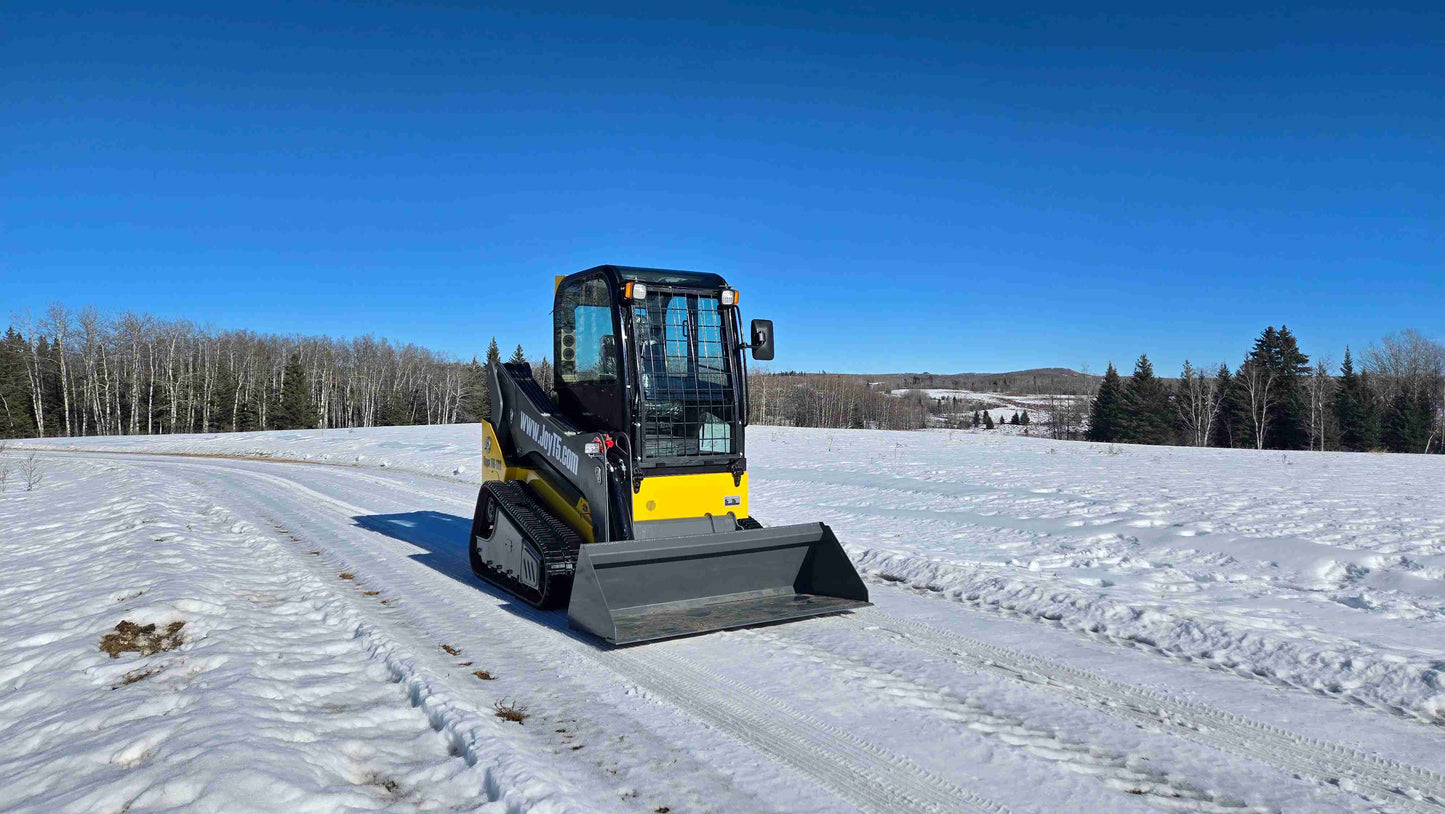 rippa NDI680 skid steer 74 HP compact tracked loader with bucket attachment working on snowy road in Canada for construction and landscaping

