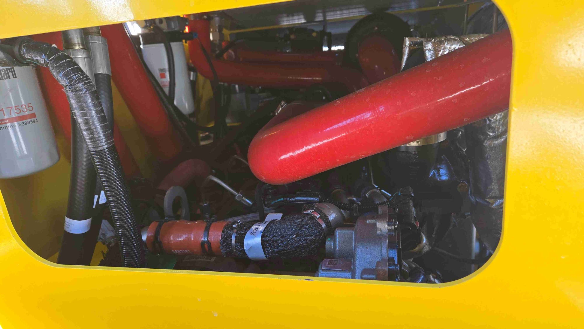 internal view of rippa NDI680 skid steer 74 HP engine compartment showing coolant pipes fuel filters and hydraulic connections in Canada

