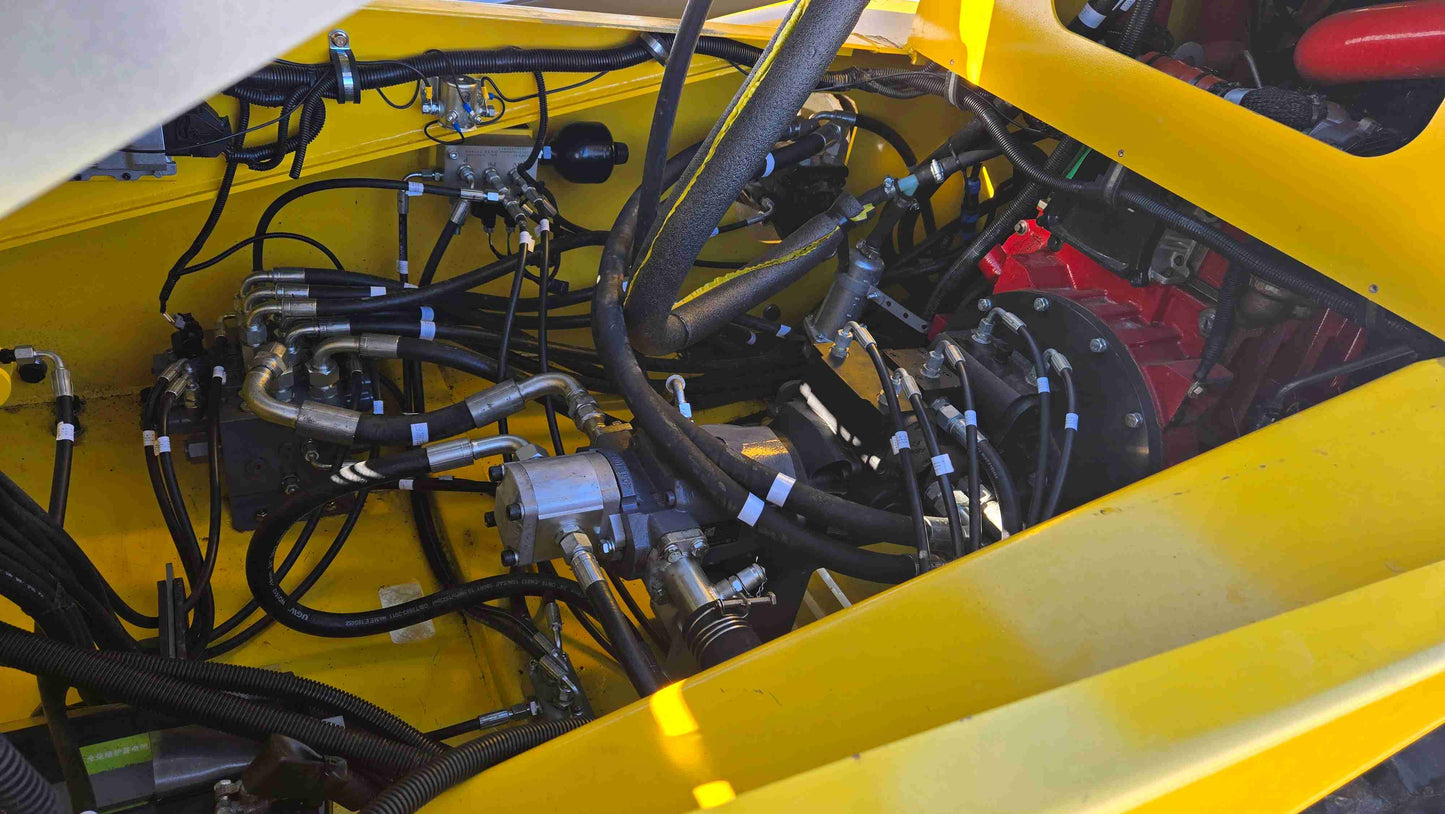 Detailed view of engine bay hydraulic system with hoses pump and valves inside Rippa NDI680 skid steer designed for heavy duty work in Canada by JoyT5