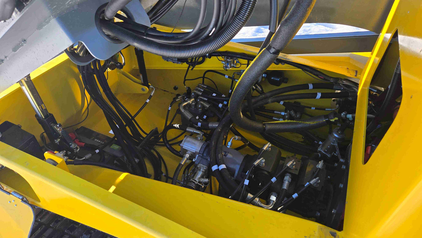 open view of rippa NDI680 skid steer 74 HP engine bay showing hydraulic pumps hoses and cylinder connections for construction in Canada