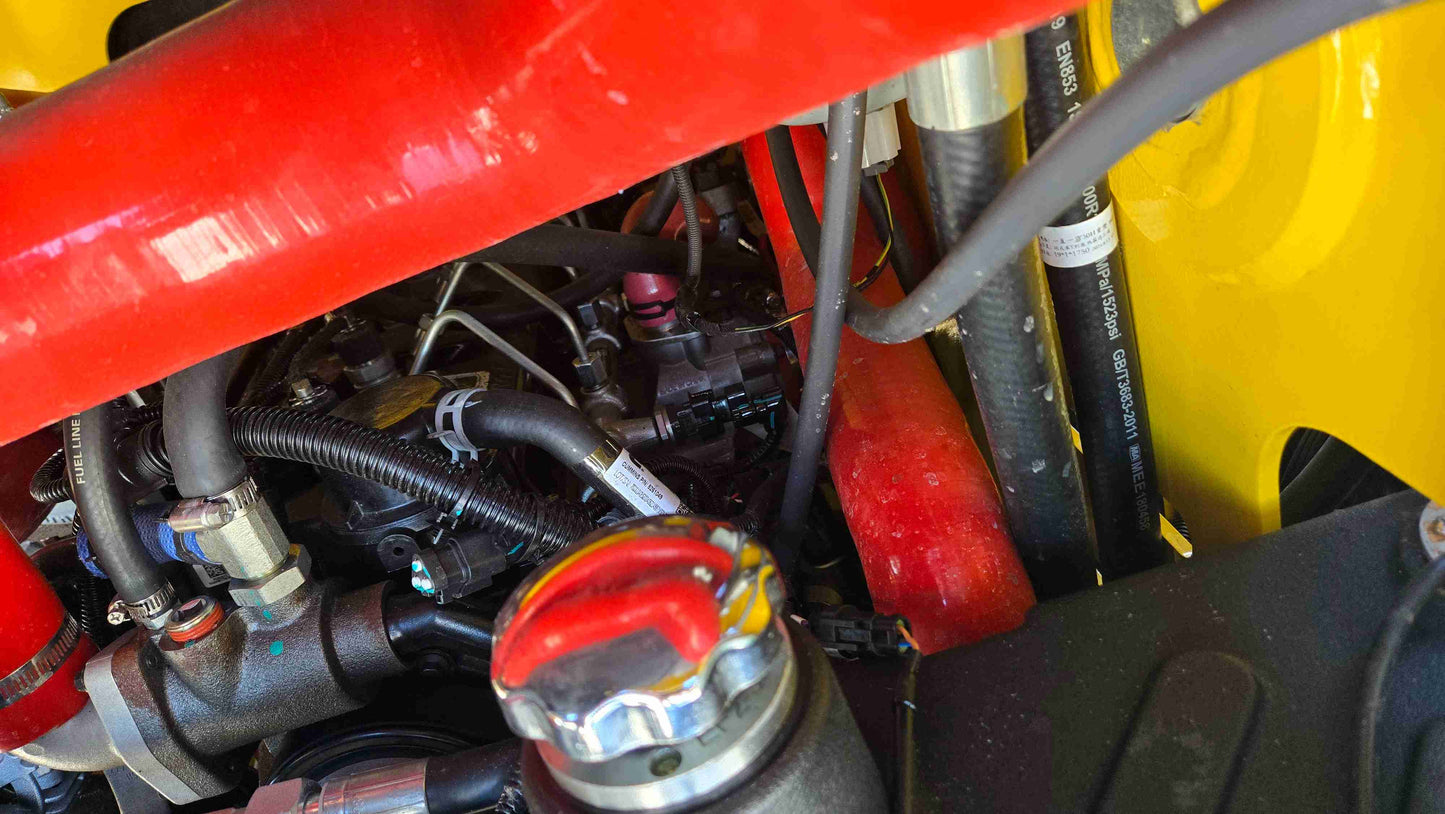 Detailed view of Rippa NDI680 skid steer hydraulic hose and engine compartment showing high pressure line setup for 74 HP Cummins skid steer used in heavy duty construction landscaping and farming work across Canada by JoyT5