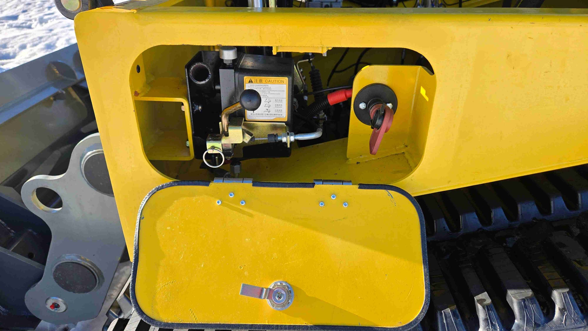 open hydraulic control valve compartment of rippa NDI680 skid steer 74 HP compact tracked loader showing maintenance and safety switch in Canada