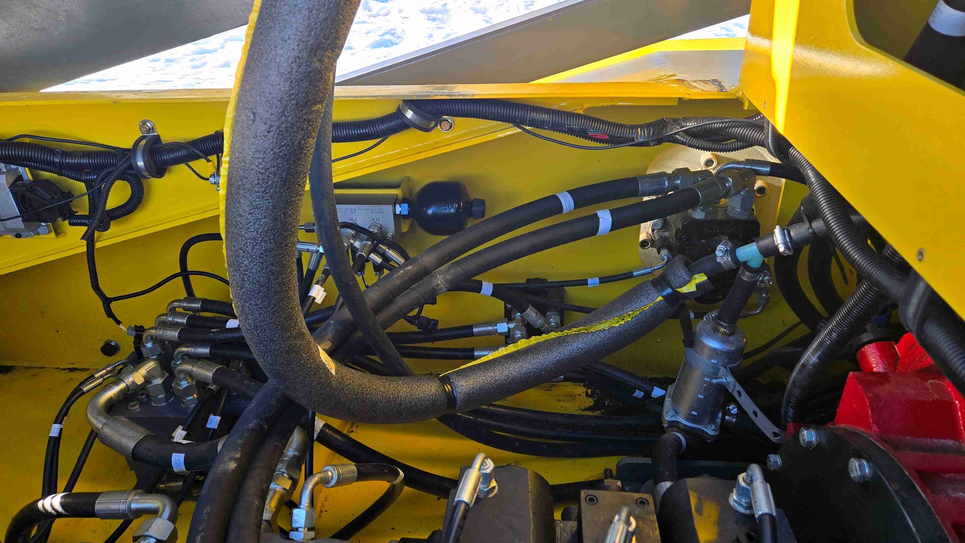 Close-up of hydraulic hoses and components inside Rippa NDI680 skid steer loader | JoyT5
