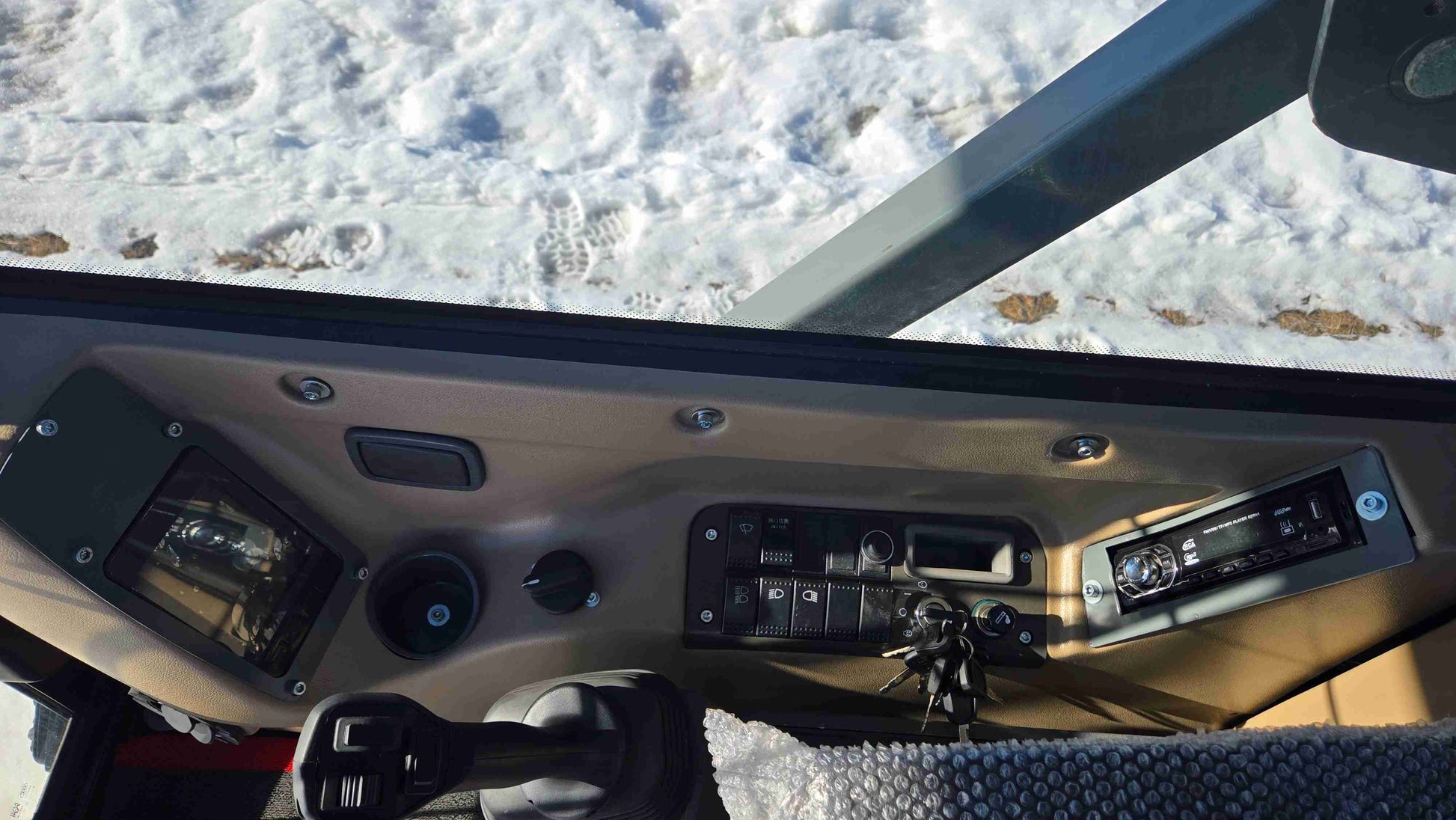 Operator control dashboard inside Rippa NDI680 skid steer enclosed cabin showing switches ignition and control panel for construction landscaping and farming use in Canada by JoyT5