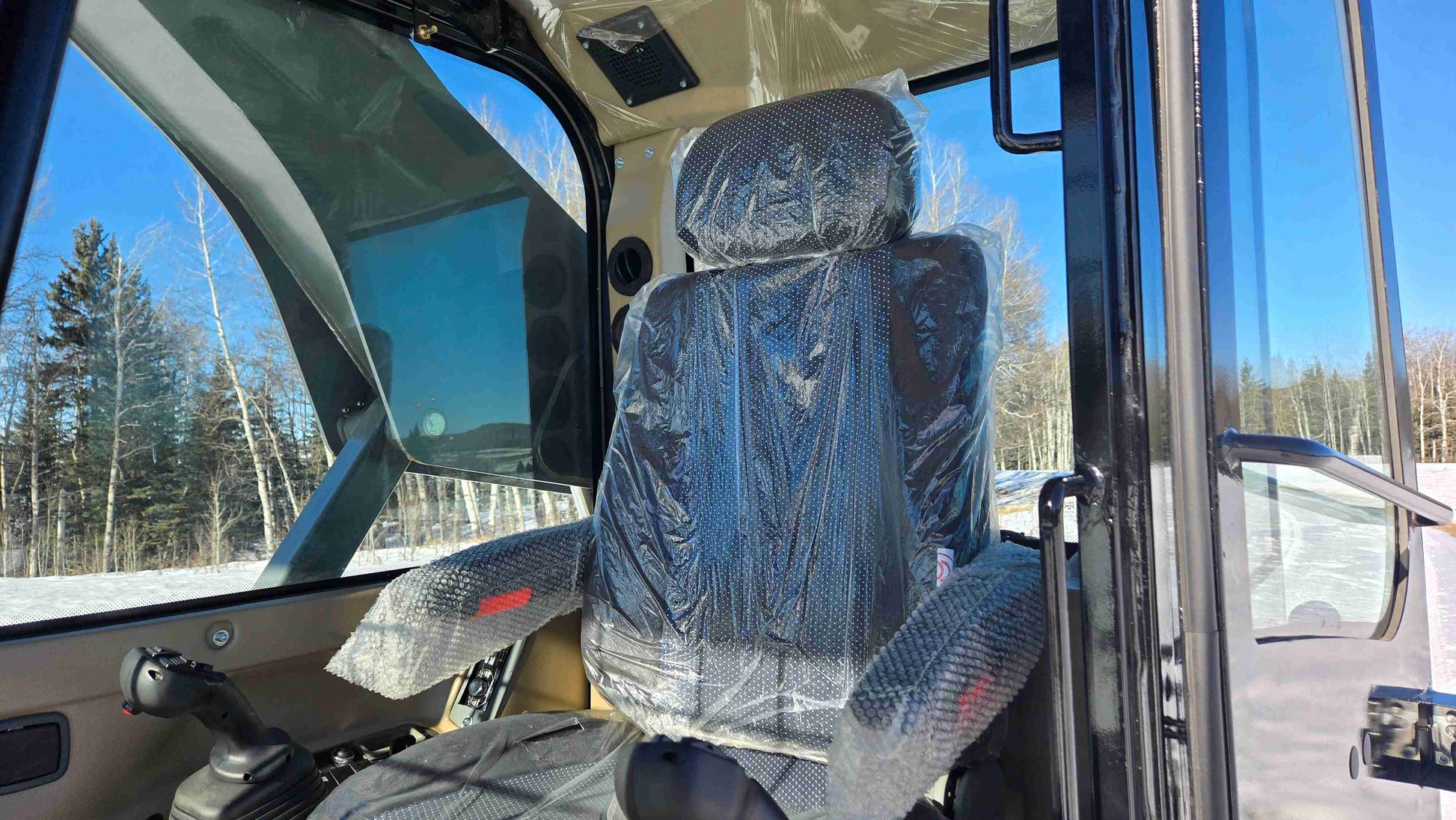 Operator seat inside Rippa NDI680 skid steer enclosed cabin showing comfortable high back seating for construction landscaping and farming work in Canada by JoyT5