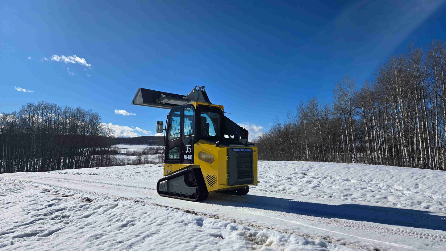 Rippa NDI680 skid steer rear angle view with raised bucket on snowy winter road in Canada by JoyT5