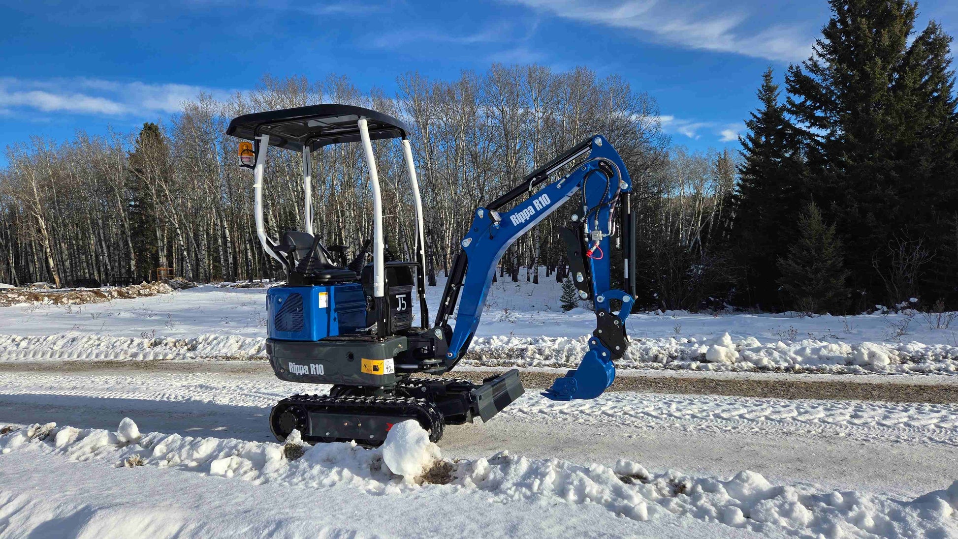 Rippa R10 1 ton mini excavator Canada side view on snowy road with JoyT5 showing compact digger for small construction and landscaping projects
