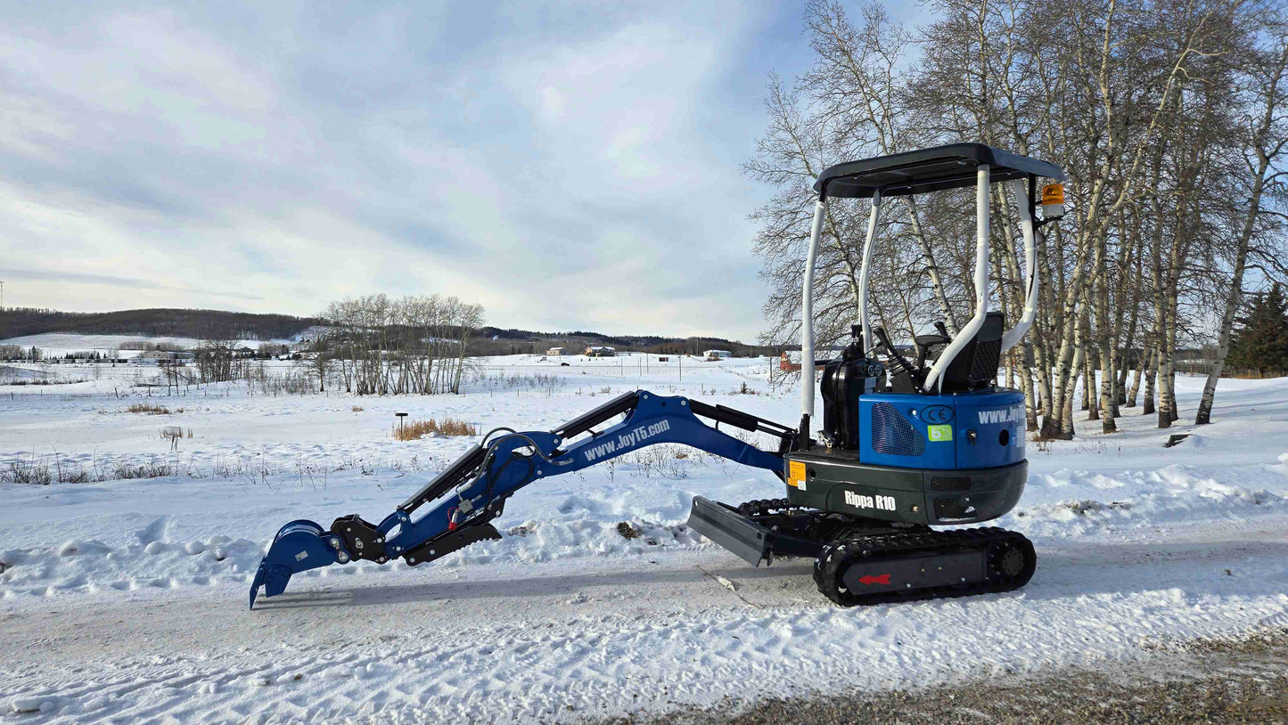Rippa R10 mini excavator with arm fully extended on snowy field in Canada, compact and powerful construction digger by JoyT5 for tight space projects.