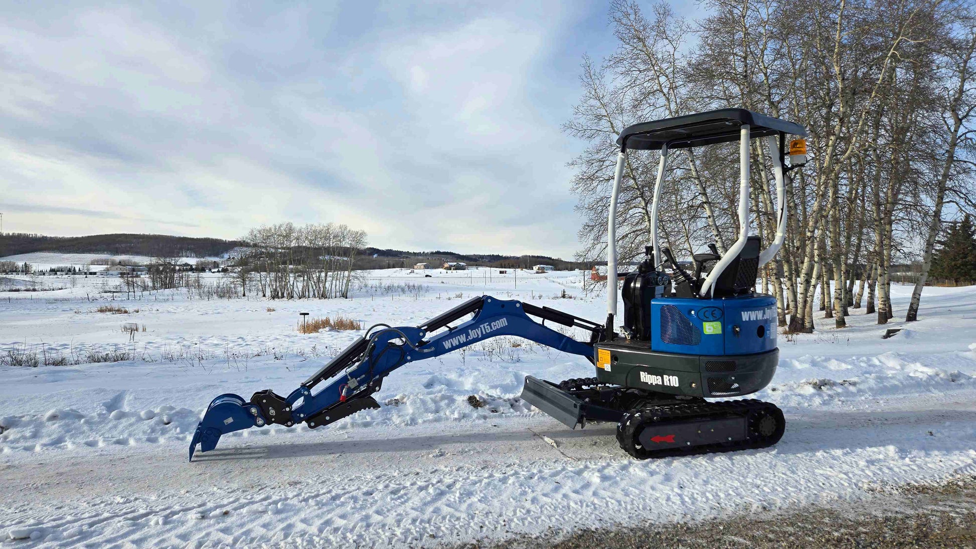 Rippa R10 mini excavator with arm fully extended on snowy field in Canada, compact and powerful construction digger by JoyT5 for tight space projects.
