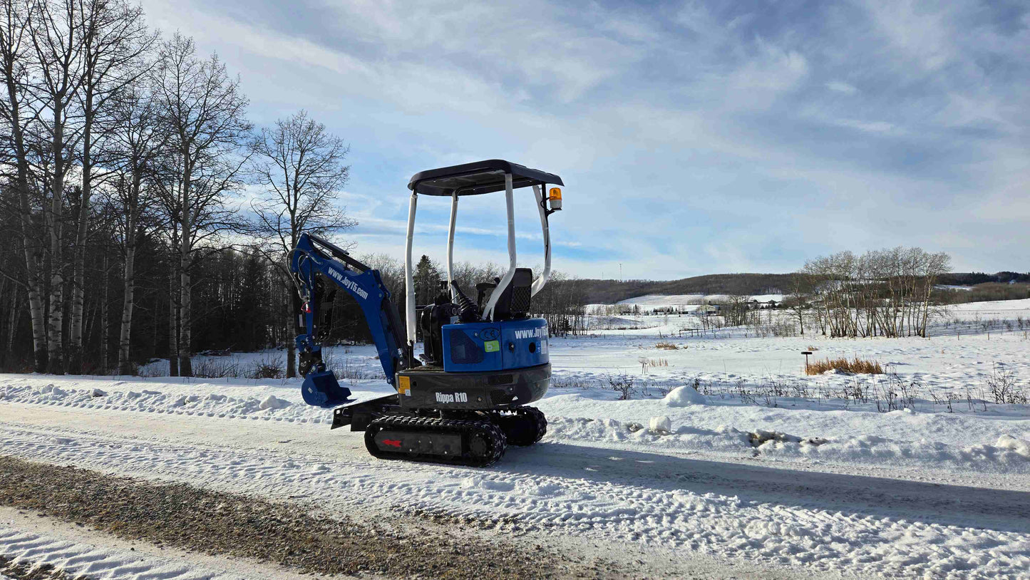 Rippa R10 mini excavator by JoyT5 parked on snowy ground in Canada, compact 1 ton digger ideal for small construction and landscaping projects.

