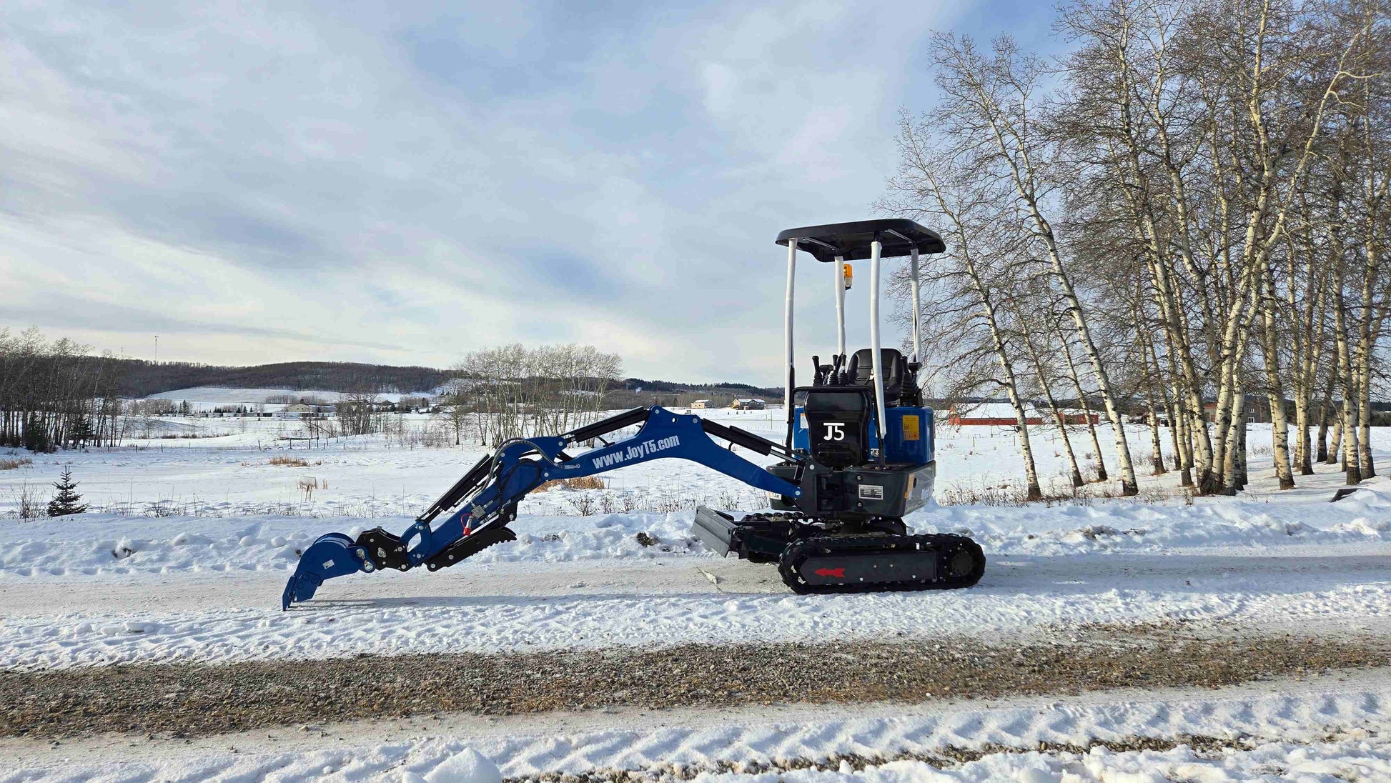 Rippa R10 mini excavator with long arm side view on snowy ground in Canada, compact and powerful construction digger by JoyT5 for tight space projects.