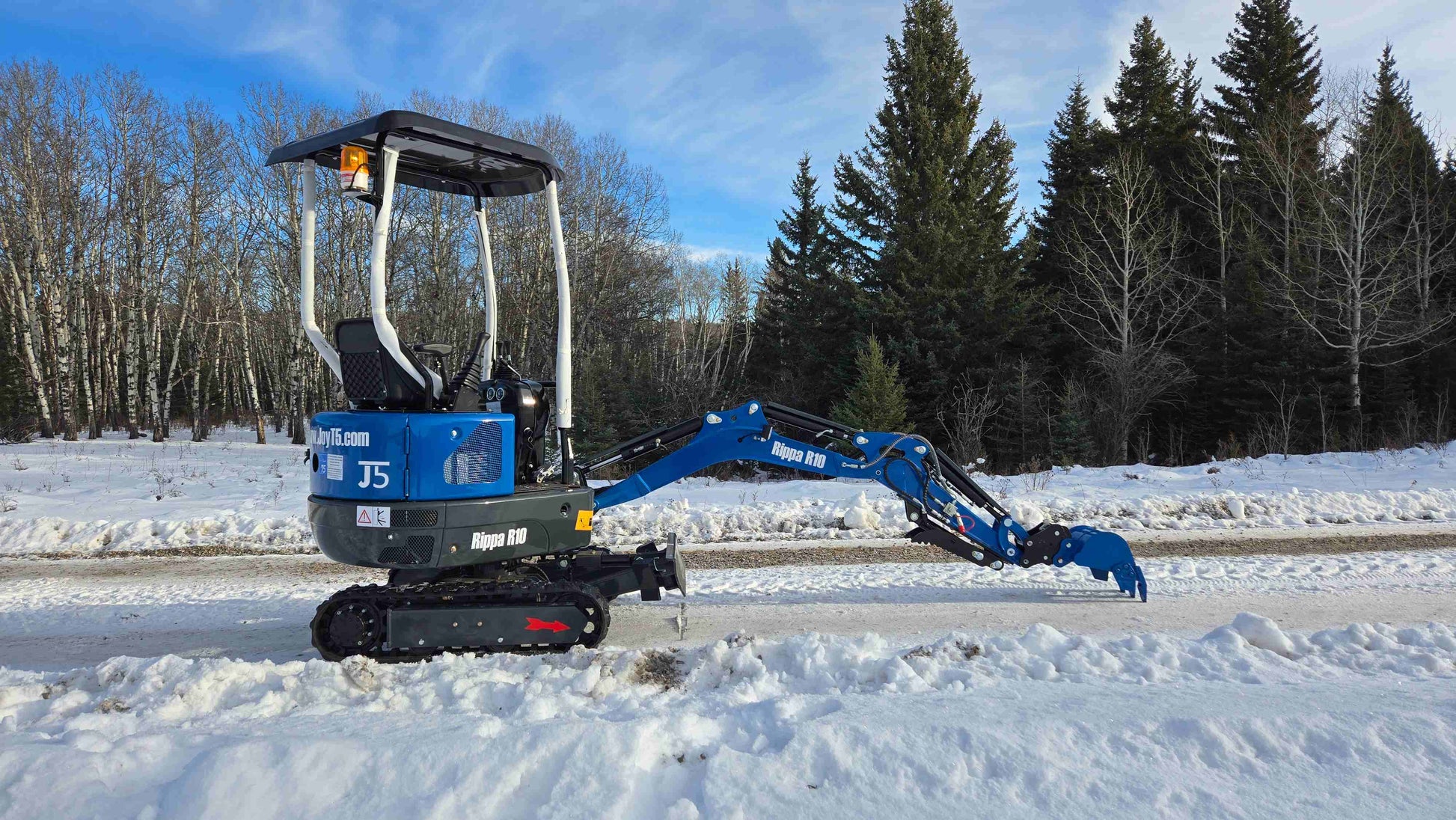 Rippa R10 Mini Excavator standing on snow with digging arm extended close to ground