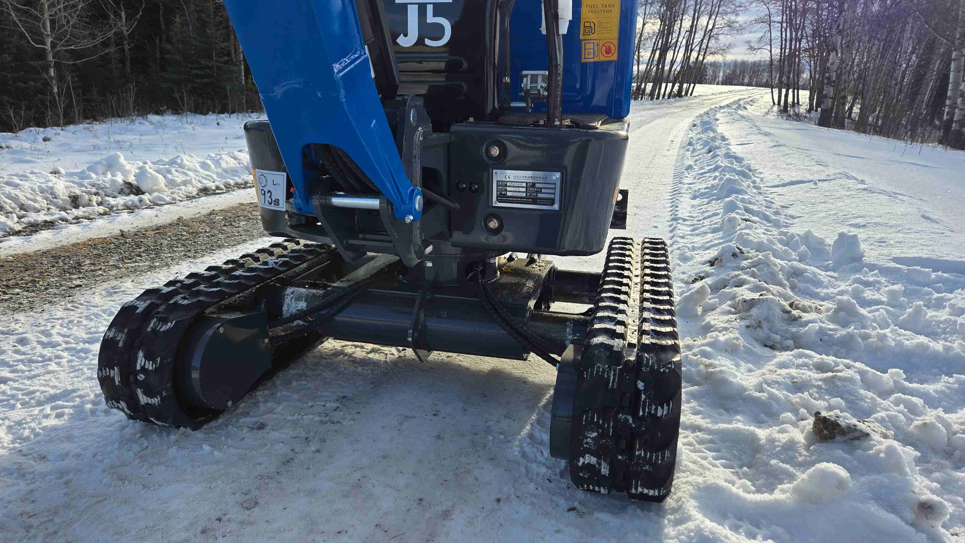 Close-up view of Rippa R10 mini excavator undercarriage and rubber tracks working on snowy ground in Canada, compact construction equipment by JoyT5.