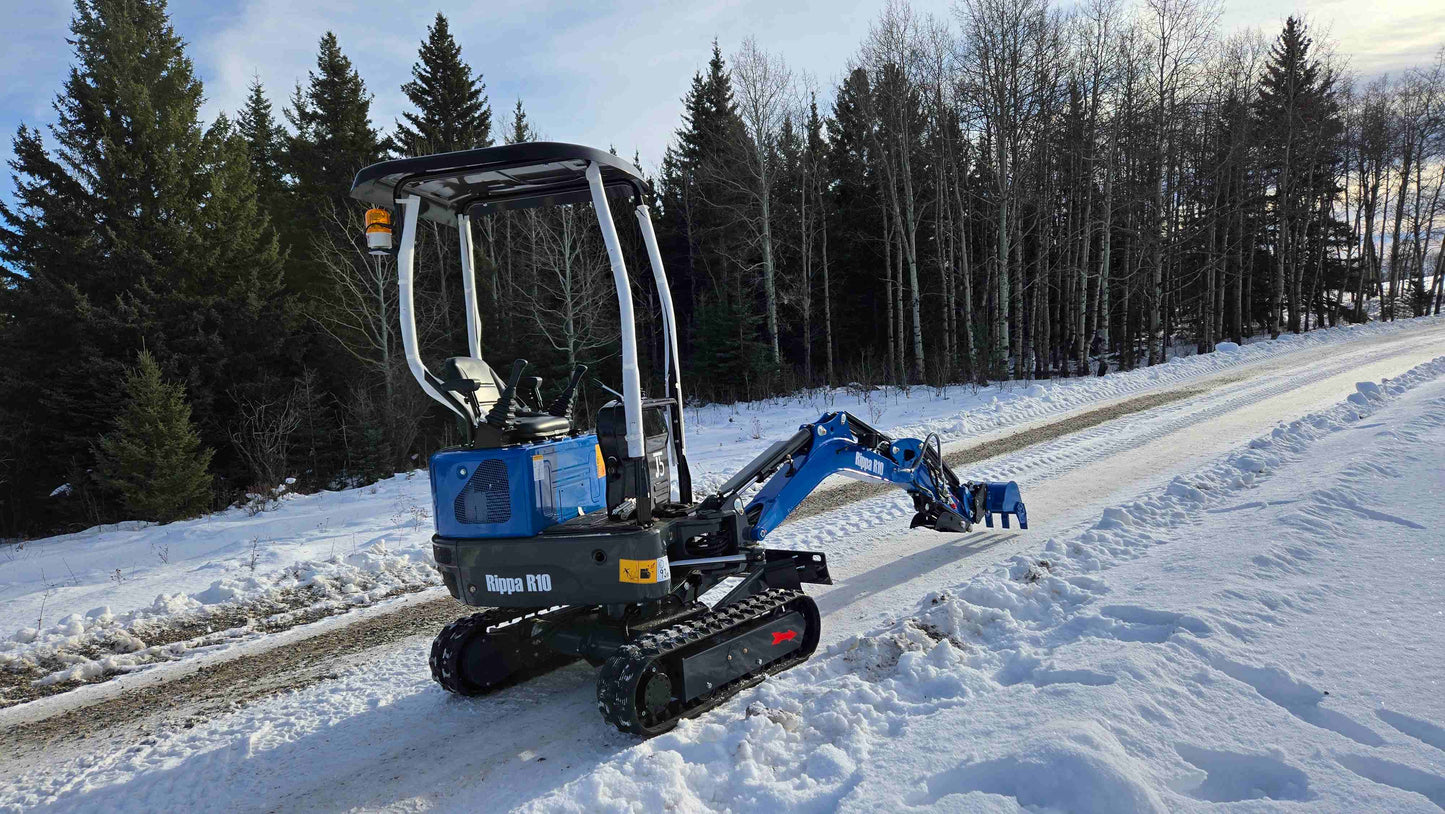 Rippa R10 mini excavator operating on snowy road in Canada, compact and powerful digger by JoyT5 for small construction and landscaping projects.