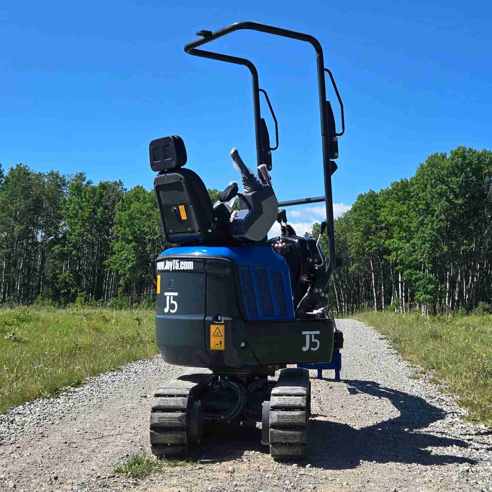 Rear view of Rippa R13 1.3 ton mini excavator showing operator seat and compact tracked design on gravel path | Small mini excavator for landscaping, construction, and farm work in Canada with JoyT5 support