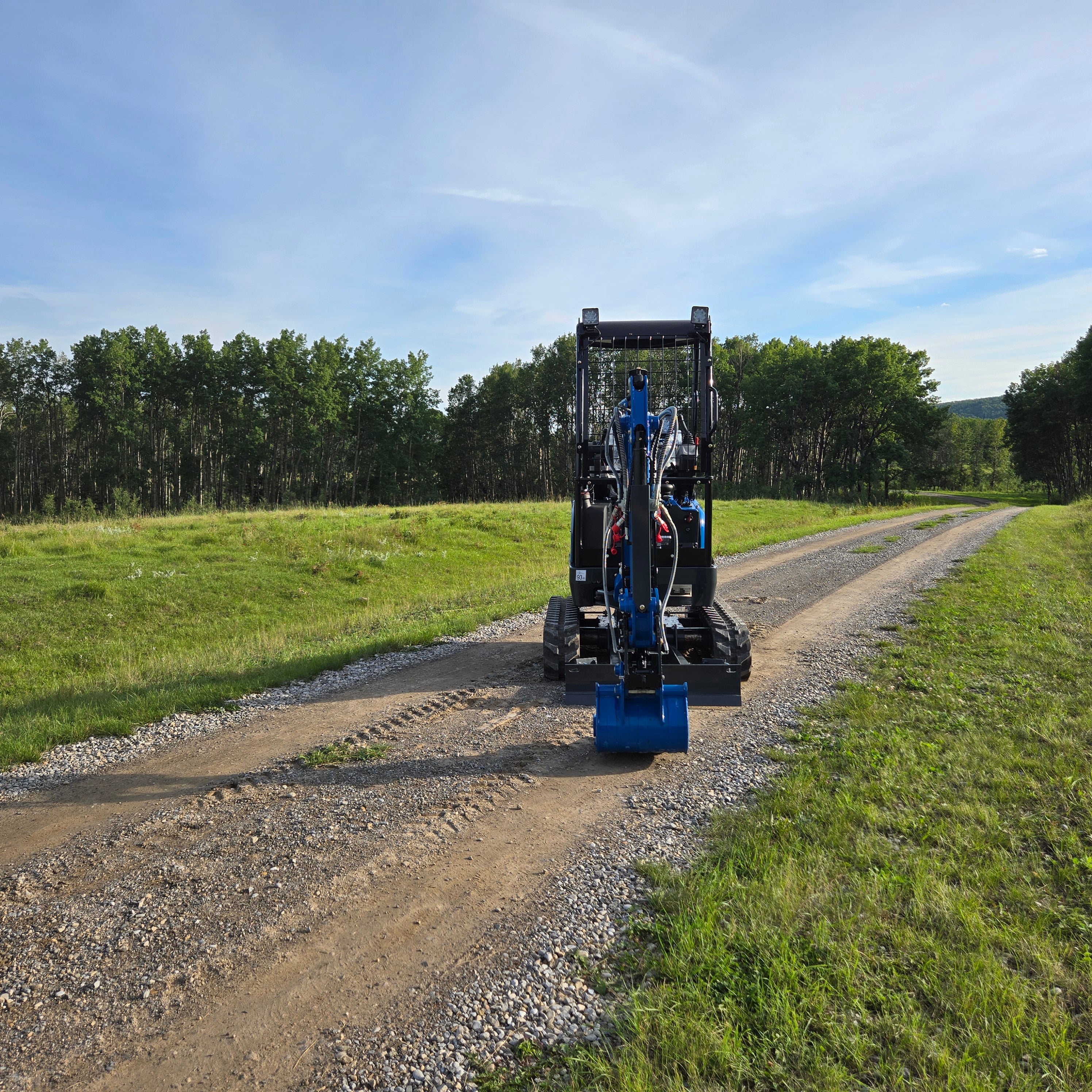 Rippa R18- mini excavator with backhoe attachment on gravel road, photographed in Canada.