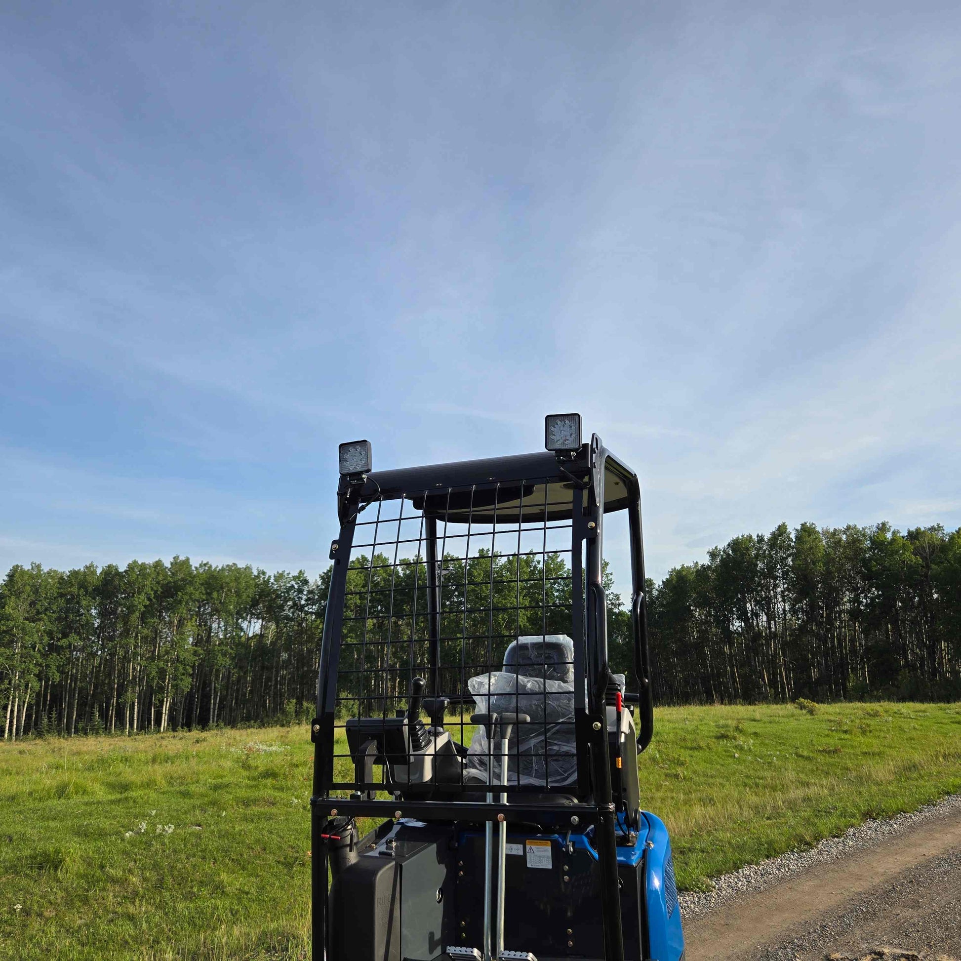 Rear cabin view of Rippa R18 mini excavator with safety grid in open field Canada | Compact excavator JoyT5 for landscaping and construction equipment use

