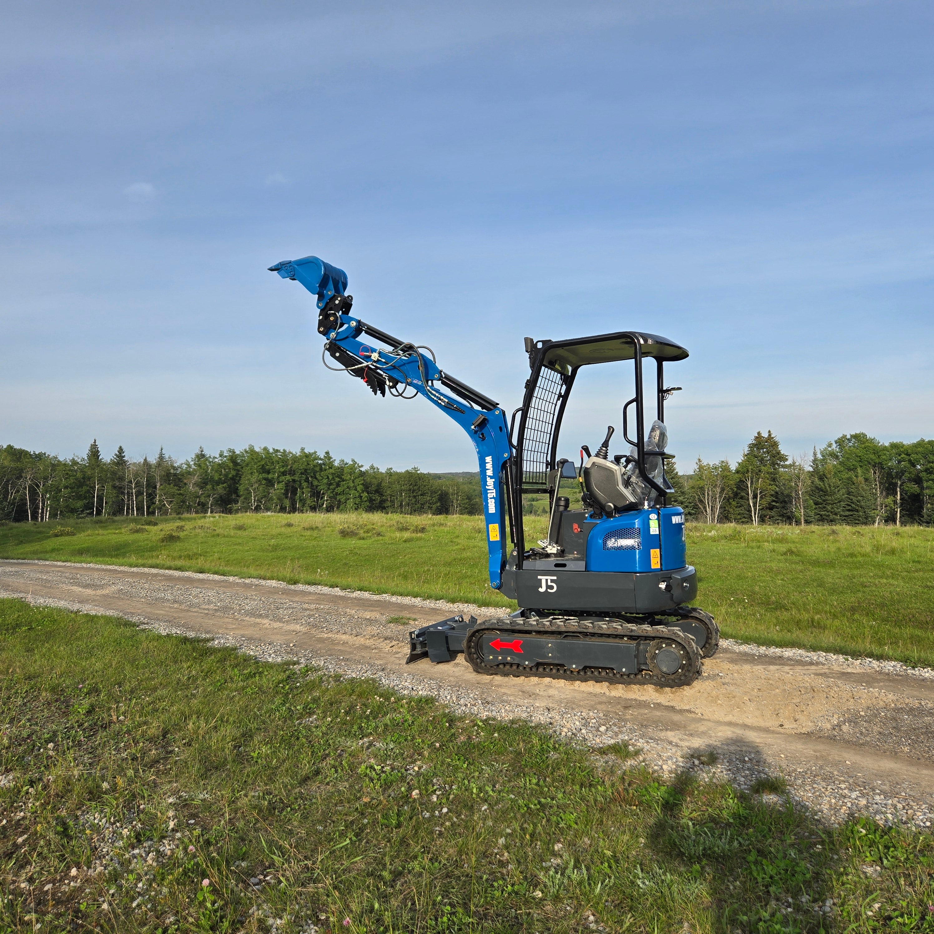 Side view of Rippa R18- Mini Excavator with raised digging bucket on gravel road.