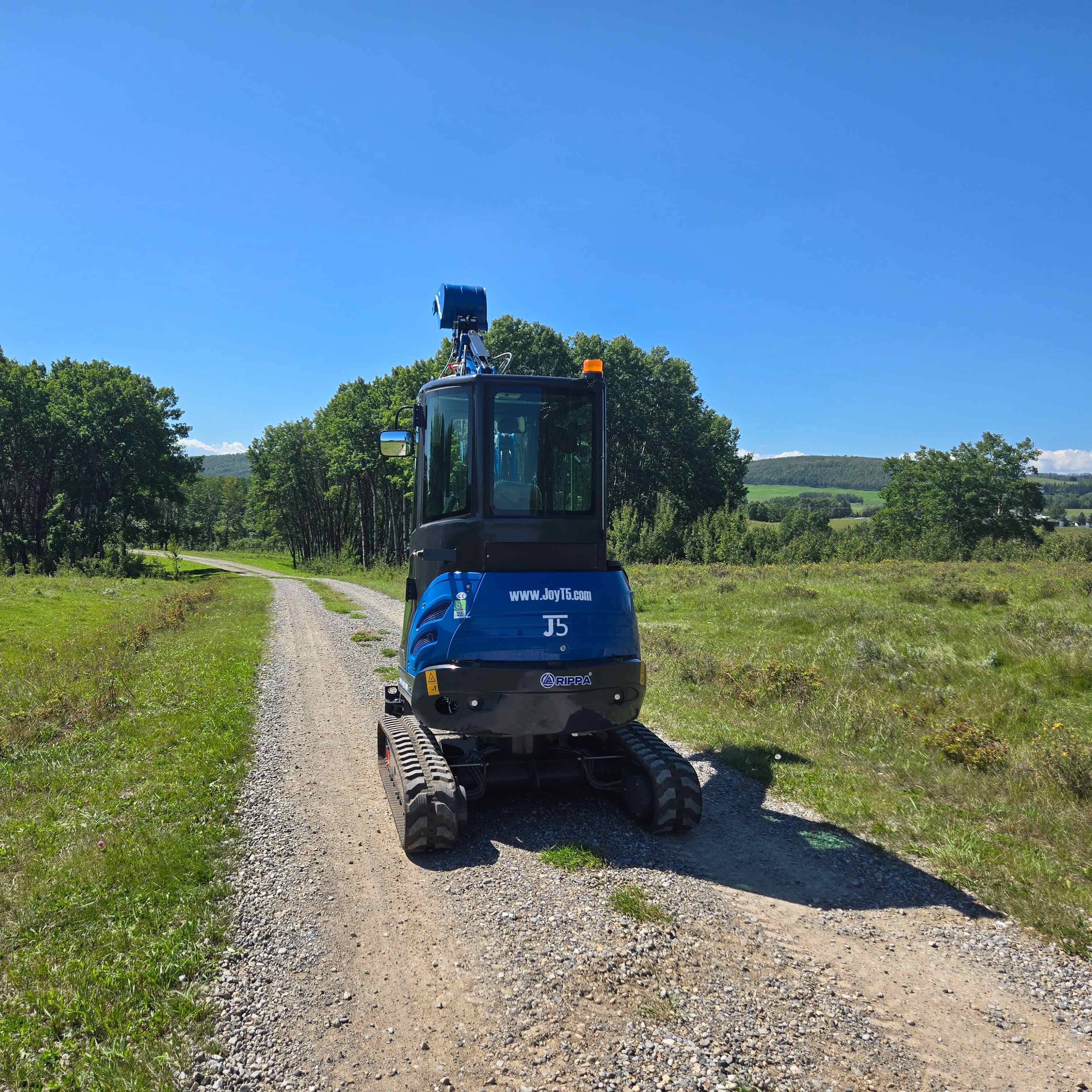 Rippa R22 2 ton mini excavator for sale in Canada from JoyT5 rear view compact excavator moving on gravel road ideal for landscaping construction projects with Yanmar engine