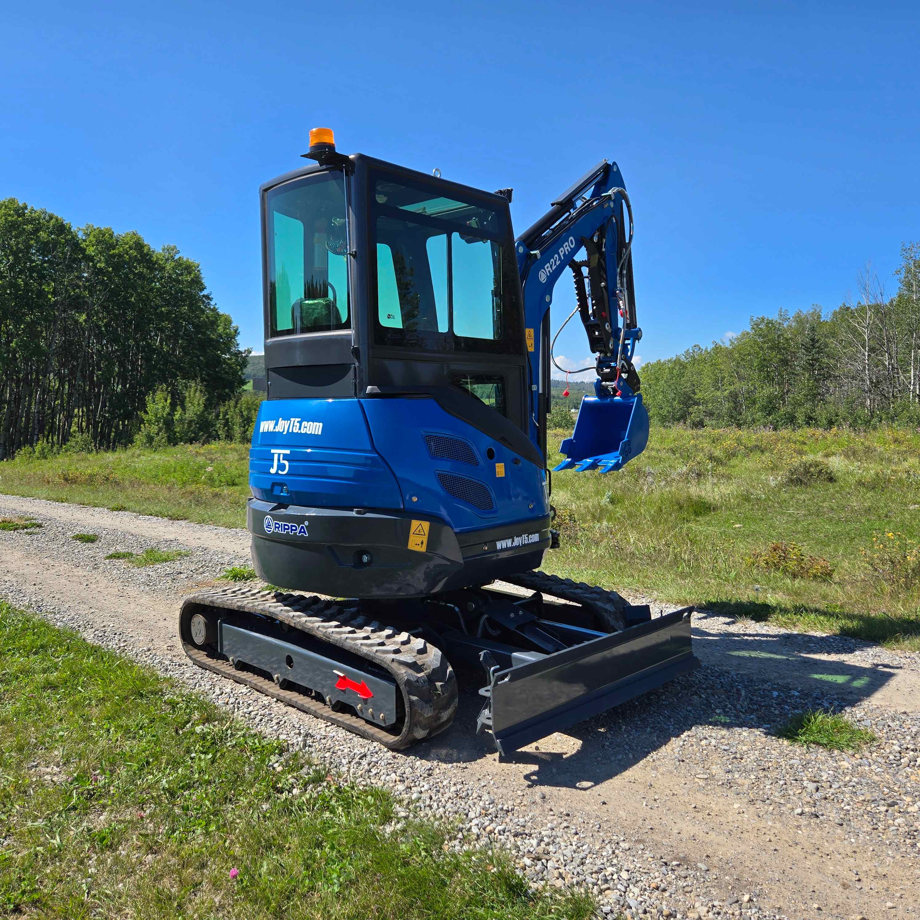 Rippa R22 2 ton mini excavator for sale in Canada JoyT5 side view compact excavator with bucket raised on gravel road for landscaping and construction work with Yanmar diesel engine