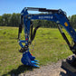 Side view of Rippa R22 Mini Excavator for sale showing boom, arm, hydraulic thumb, and digging bucket attachment in a grassy field.

