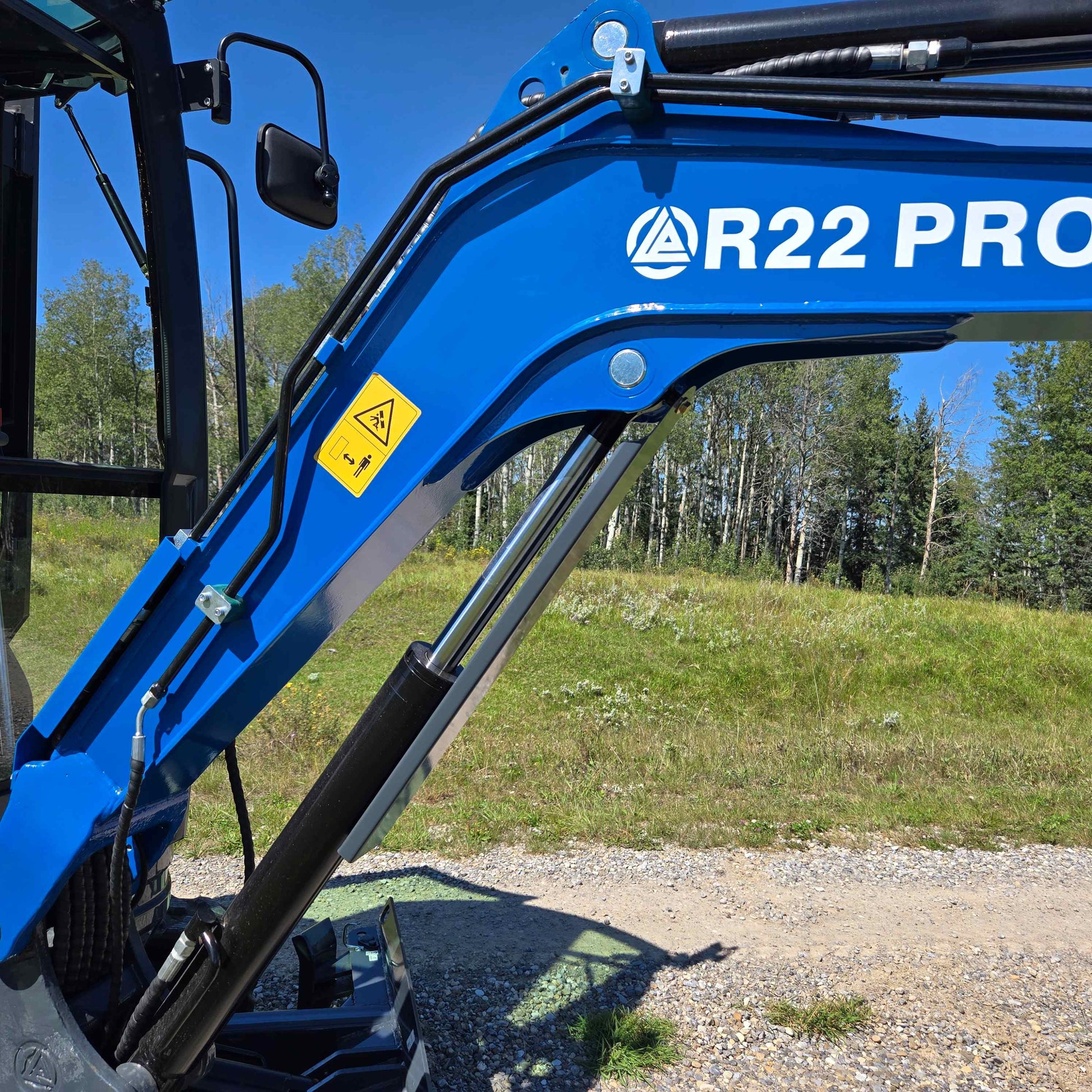Rippa R22 mini excavator for sale boom showing hydraulic cylinder, hoses, and safety label for stable lifting performance.
