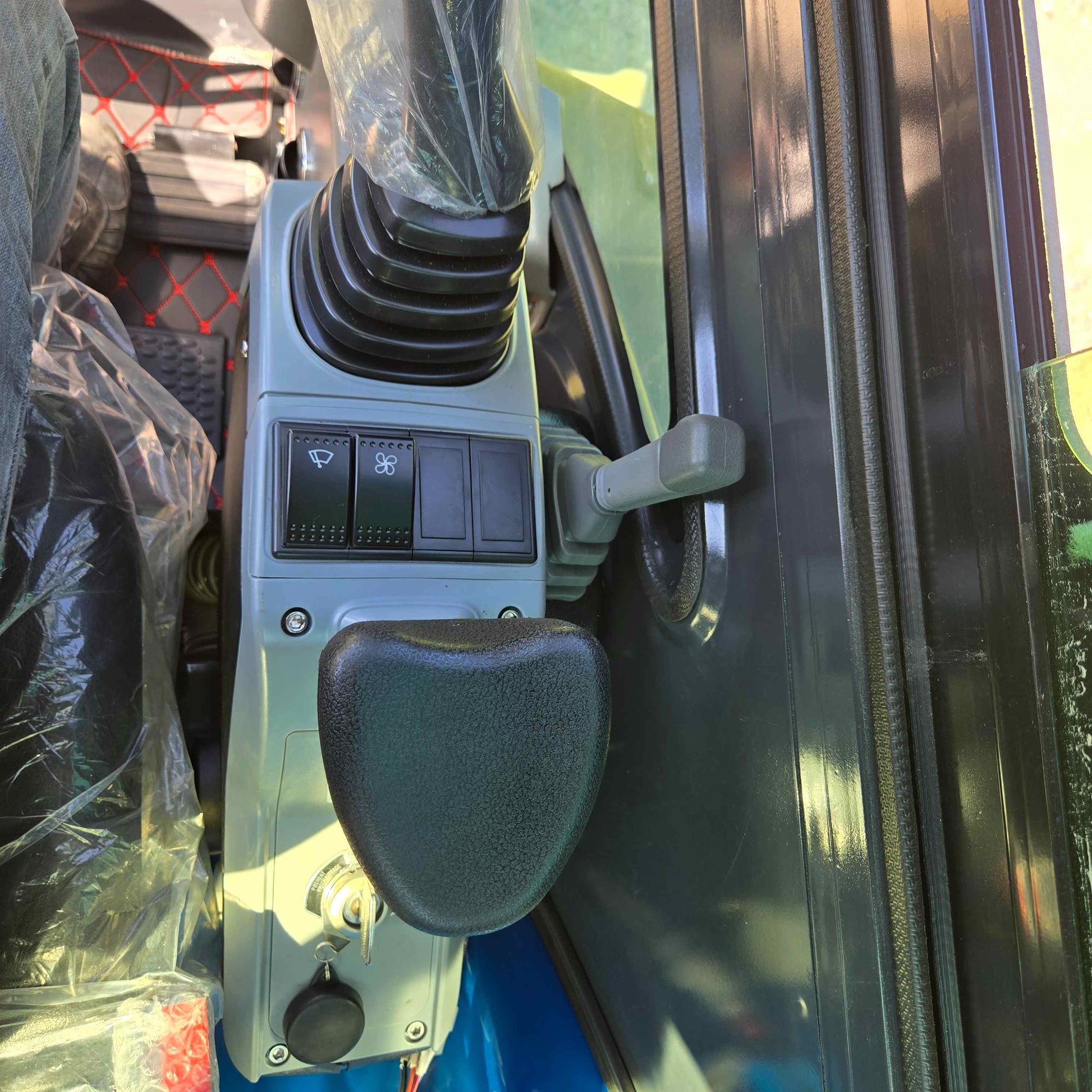 Close-up view of Rippa R22 Mini Excavator for sale control panel with joystick, switches, and ignition key.
