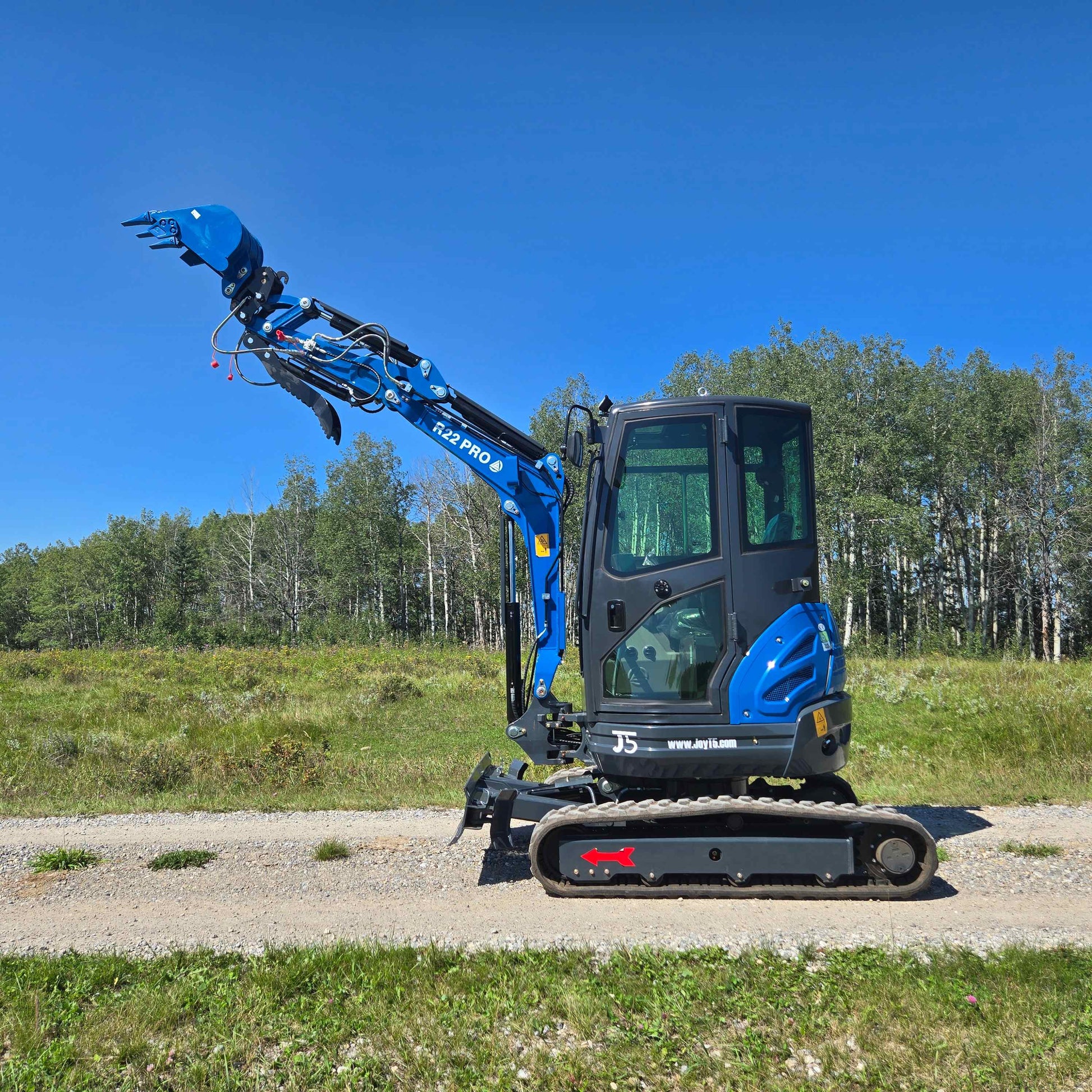 Rippa R22 Mini Excavator for sale full side view with raised bucket on outdoor gravel road.
