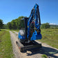 Rippa R22 Mini Excavator for sale with bucket attachment on a gravel rural road in a green field.
