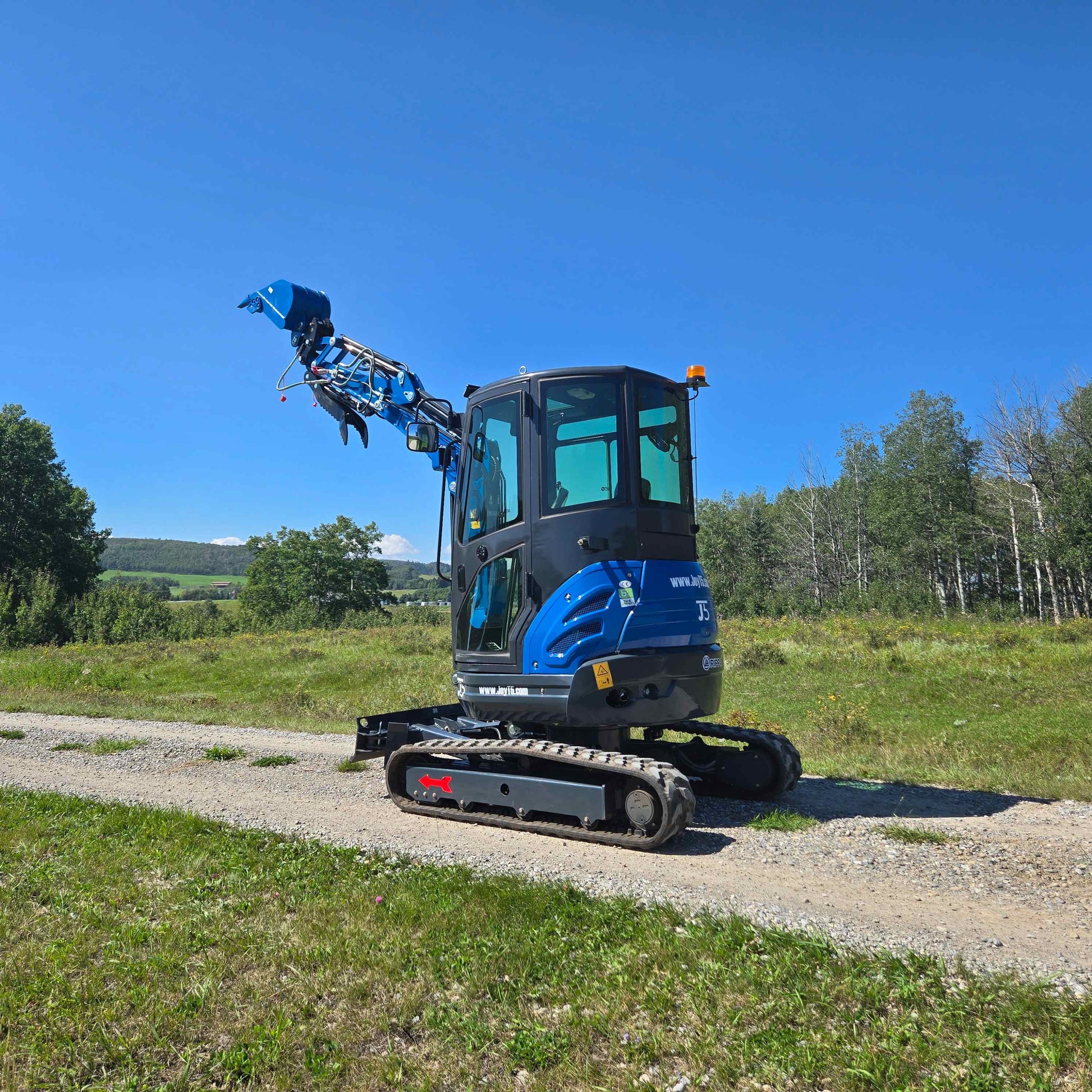 Rippa R22 Mini Excavator for sale rear side view with lifted bucket on gravel road.
