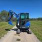 Side view of the Rippa R22 Mini Excavator for sale with cabin and boom arm extended on a gravel path.
