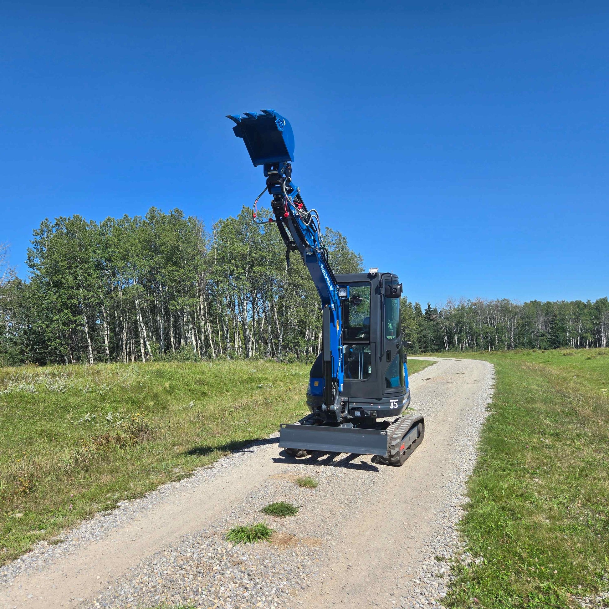 Rippa R22 Mini Excavator with front bucket lifted – Compact excavator working on rural road.
