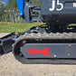 Close-up view of rippa r15 mini excavator for sale J5 rubber track and undercarriage with red arrow marking