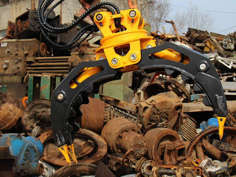 Rotating grapple attachment lifting scrap metal for demolition and material handling work with excavator in Canada