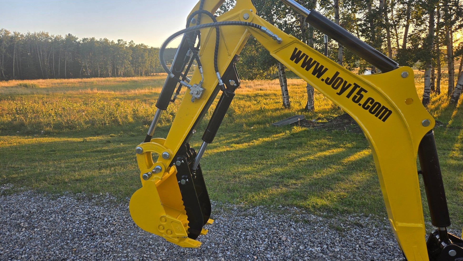 Close-up of YardHoe YH12 mini excavator bucket and hydraulic arm with www.JoyT5.com branding.
