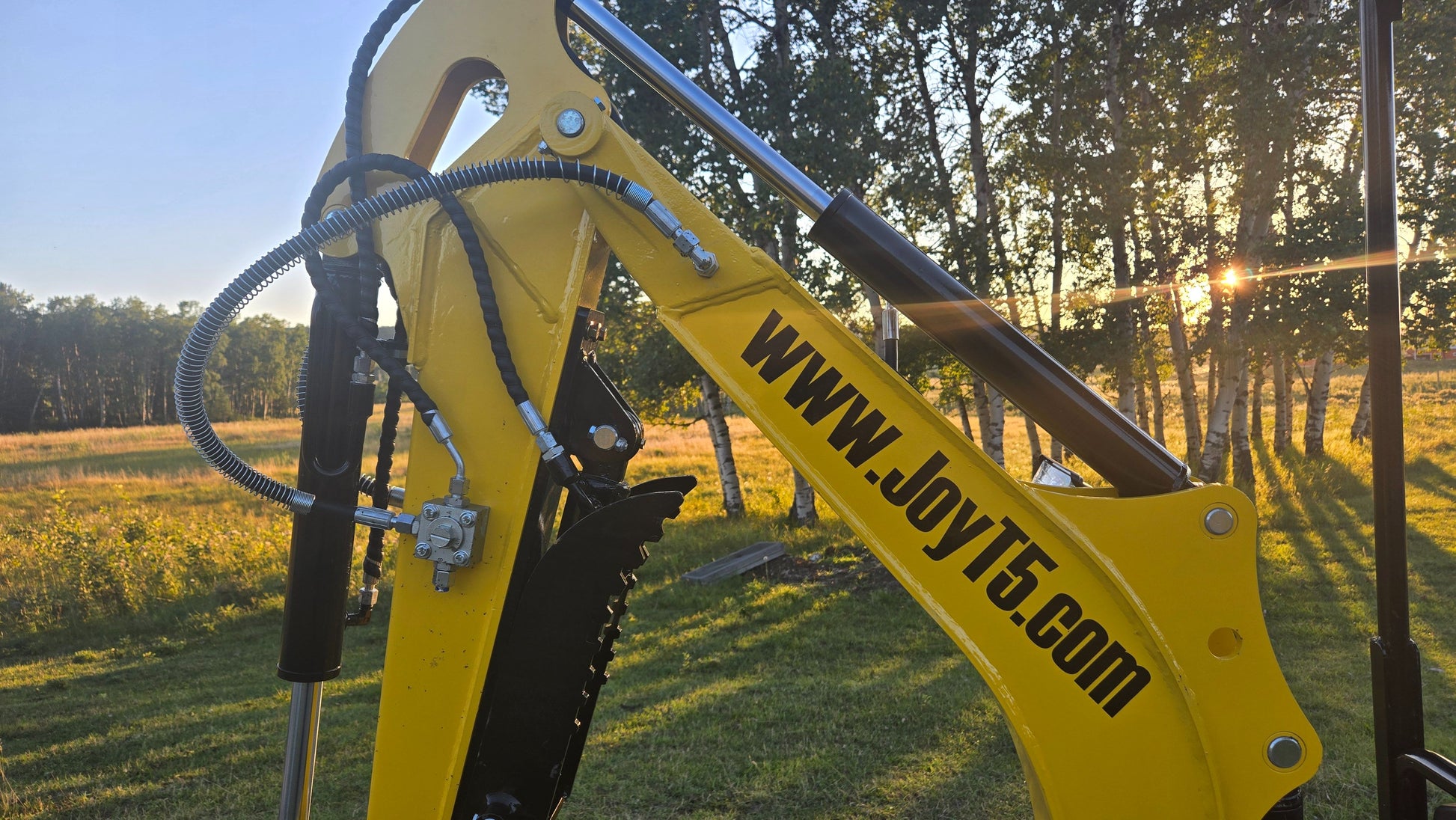 Close-up of YardHoe YH12 / Rippa R319 mini excavator boom and hydraulic arms, compact digger attachment for construction and landscaping.
