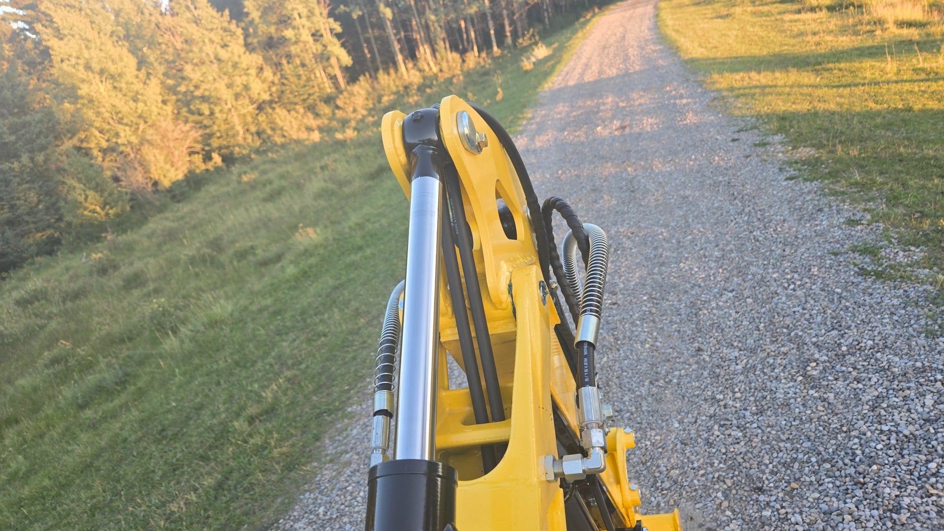 Hydraulic cylinder and hoses on the boom of YardHoe YH12 / Rippa R319 mini excavator.

