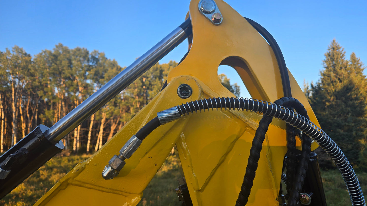 Close-up of YardHoe YH12 / Rippa R319 mini excavator hydraulic cylinder and reinforced hoses for reliable digging performance.
