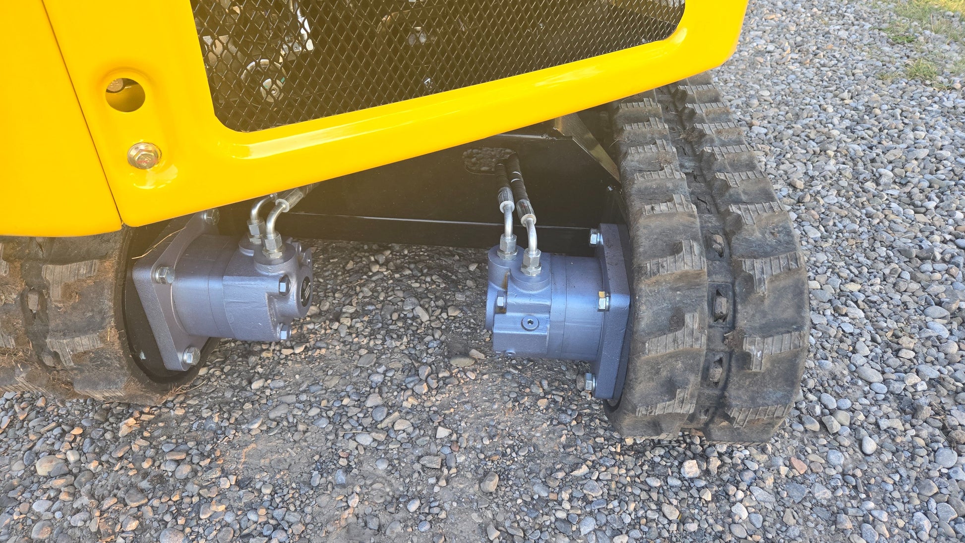 Close-up of YardHoe YH12 / Rippa R319 mini excavator rubber tracks and hydraulic drive motors for smooth movement and durability.
