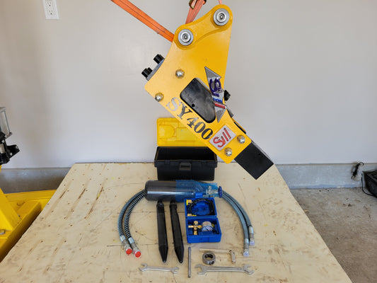 Hydraulic breaker hammer for excavators Canada and USA complete attachment set showing main hammer body with hoses chisels and tool accessories for heavy duty demolition and construction work.


